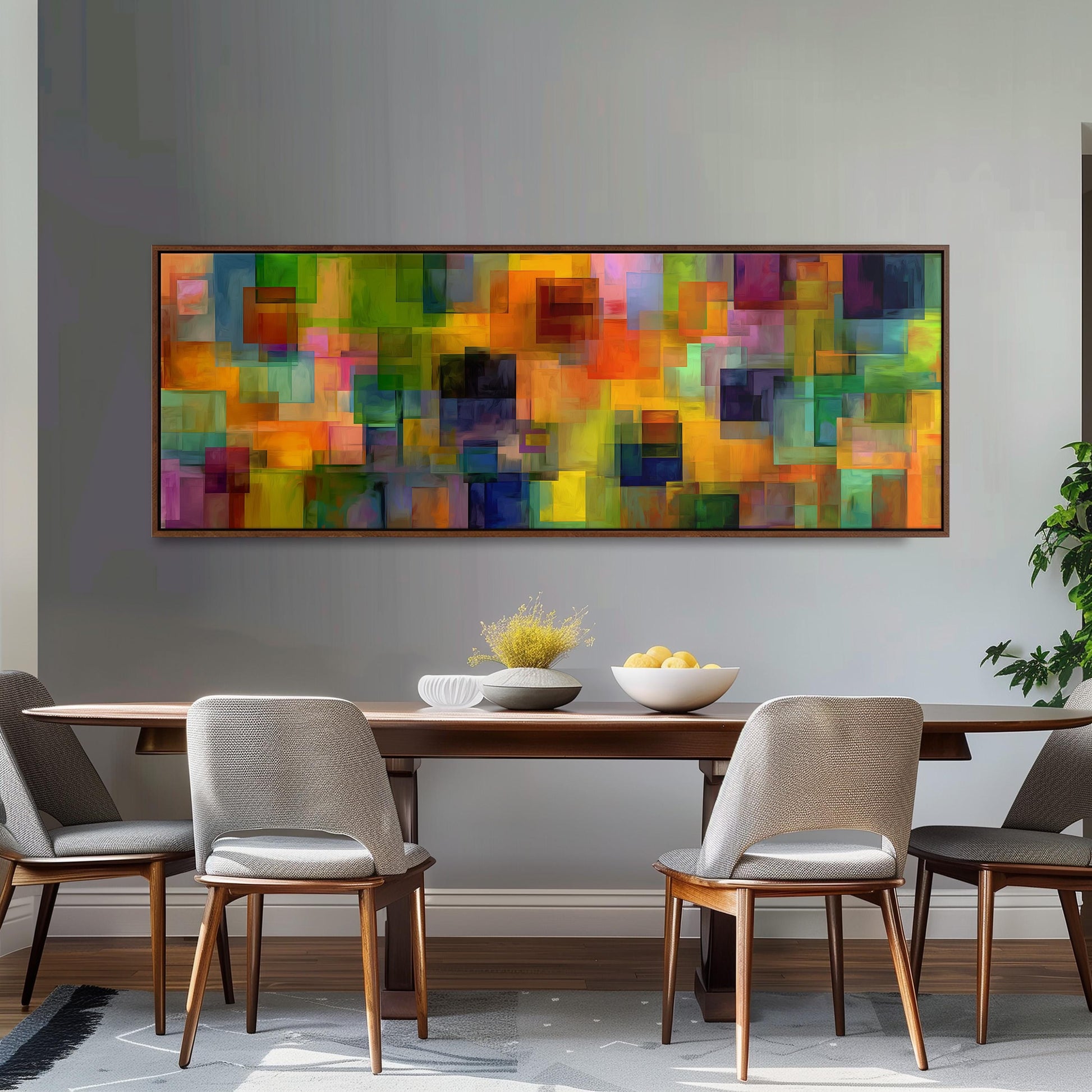 a modern dining room with a large abstract painting hanging on the wall above a wooden dining table with four chairs. The table is set with a bowl of fruit and a vase of flowers, creating a welcoming and stylish atmosphere.