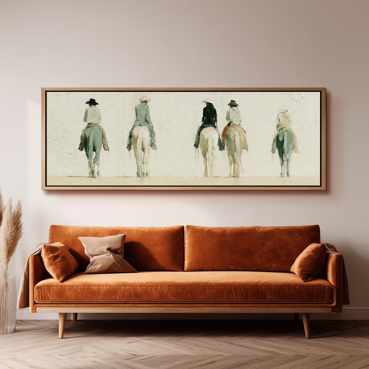 Riders on horseback seen from behind panoramic canvas print above a sofa in a living room
