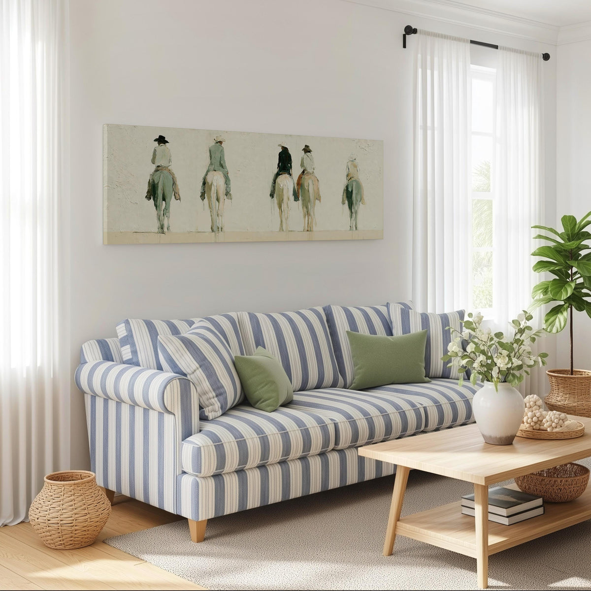 Riders on horseback seen from behind long horizontal canvas print above a striped sofa in a coastal living room