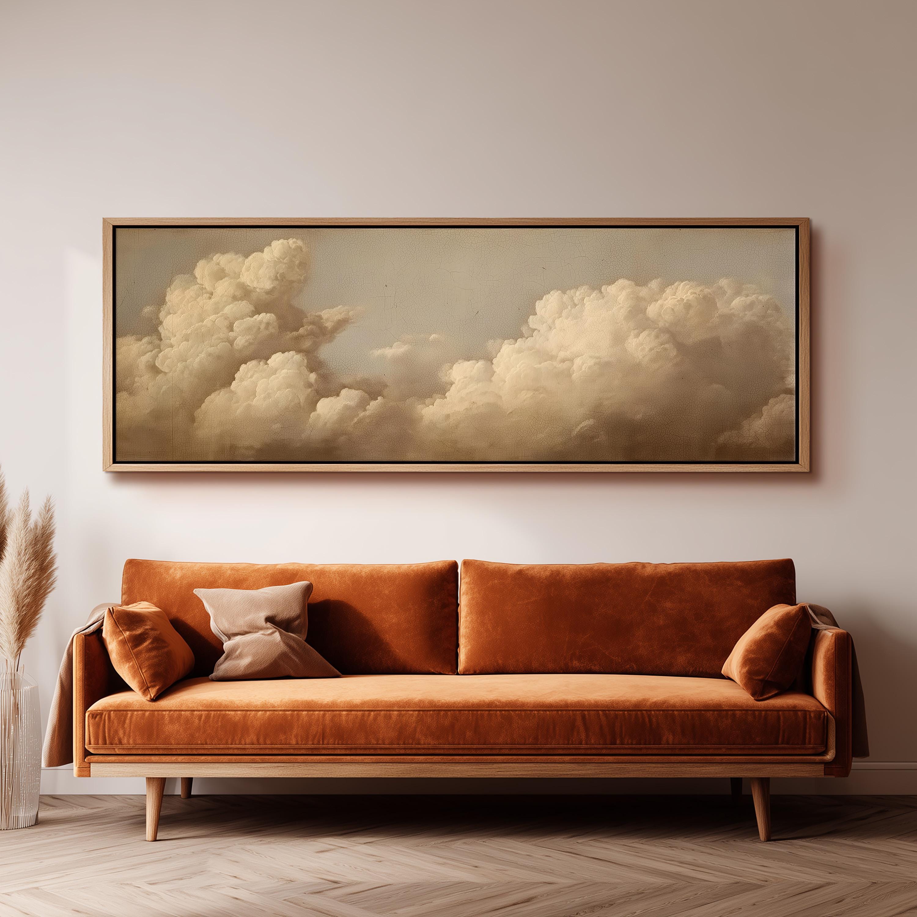 a large, framed painting of a cloudy sky hanging on a wall above a brown sofa with orange cushions.