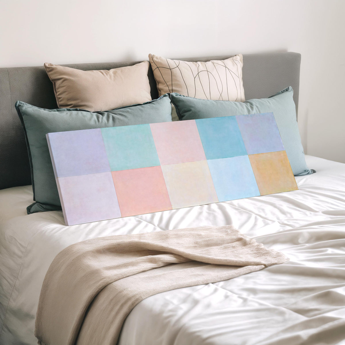 Pastel checkerboard grid wide panoramic canvas print laid on a bed to show its size