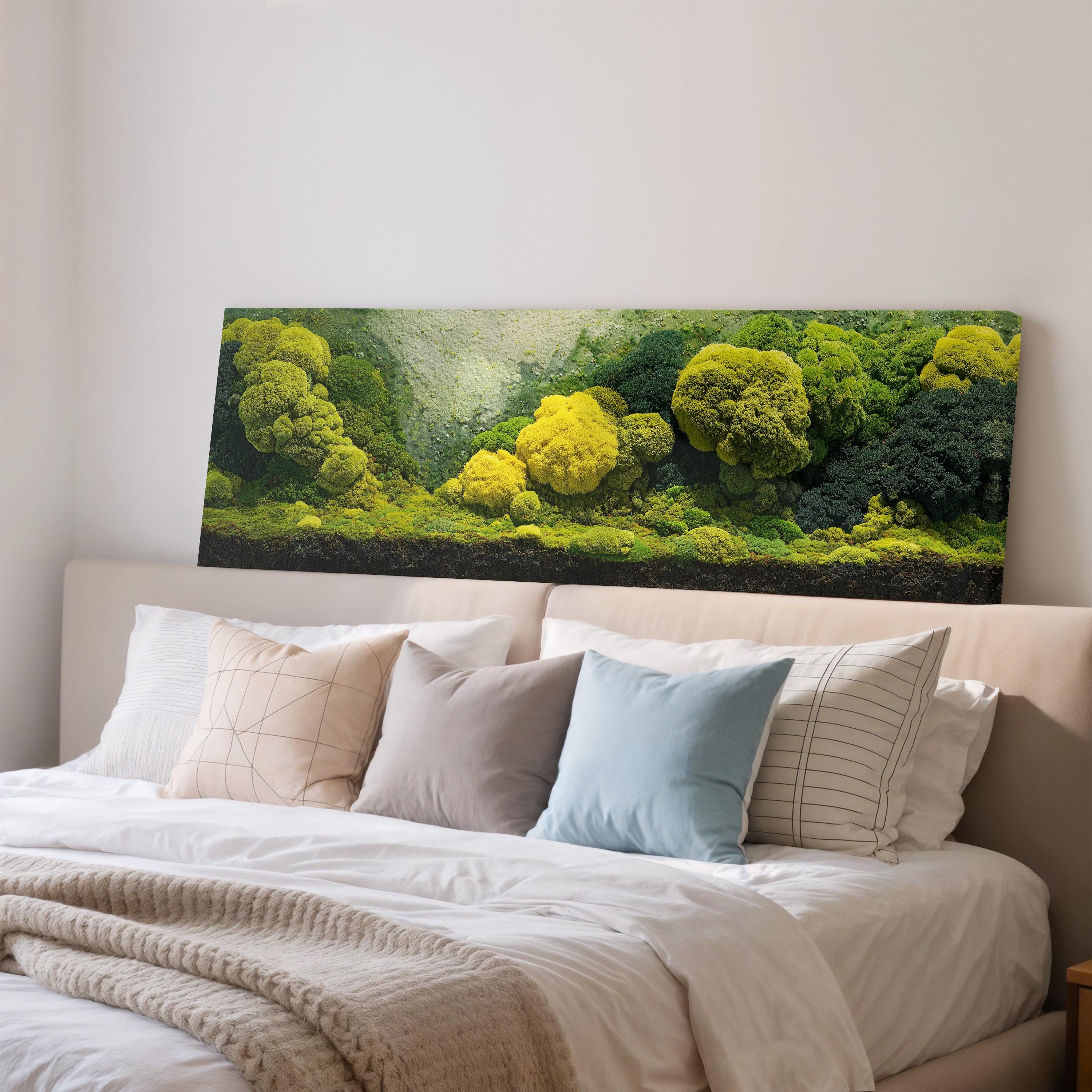 a large, lush green moss-covered wall behind a bed with white pillows and a gray blanket.
