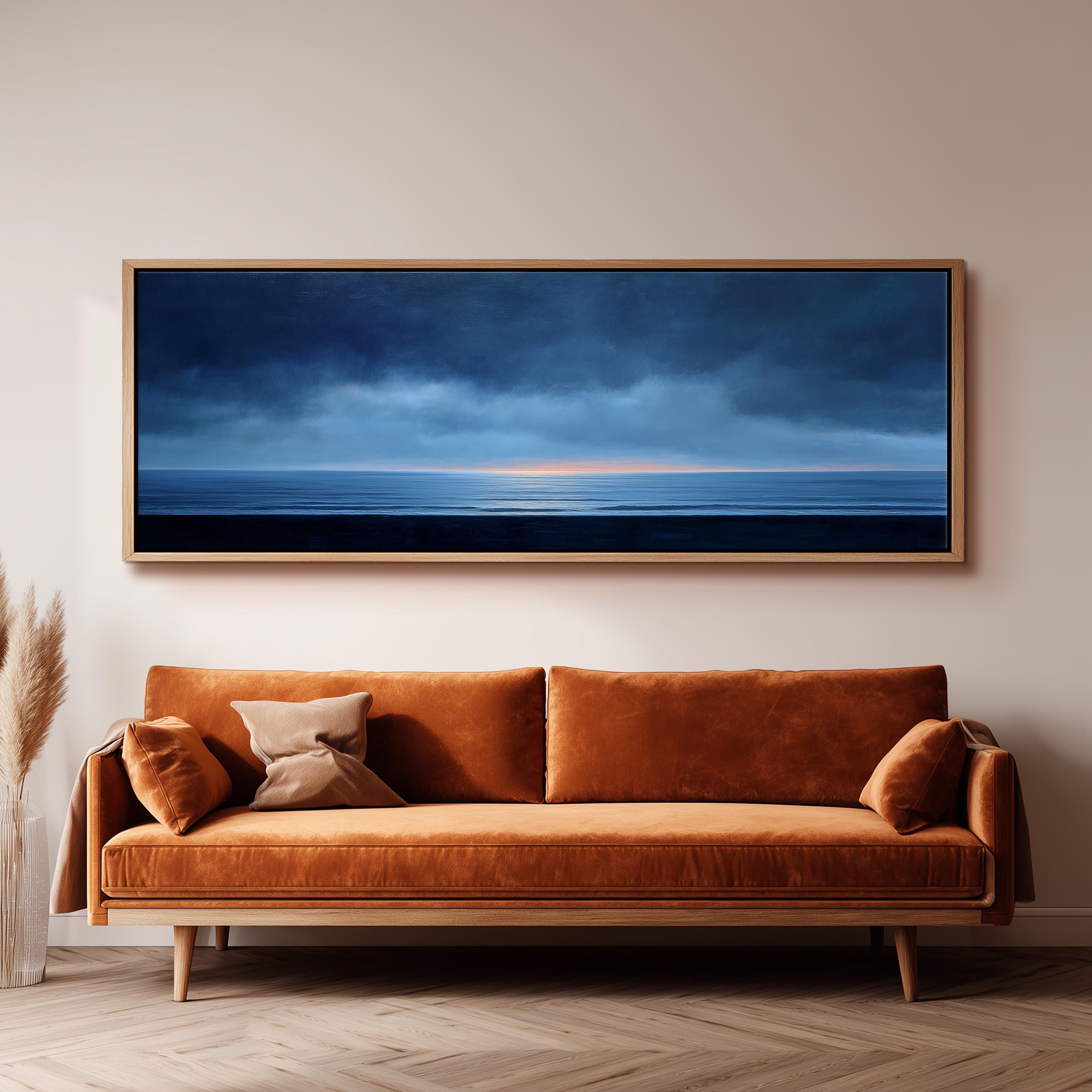 a large, rectangular painting of a serene ocean scene hanging on a wall above a brown sofa with orange cushions.
