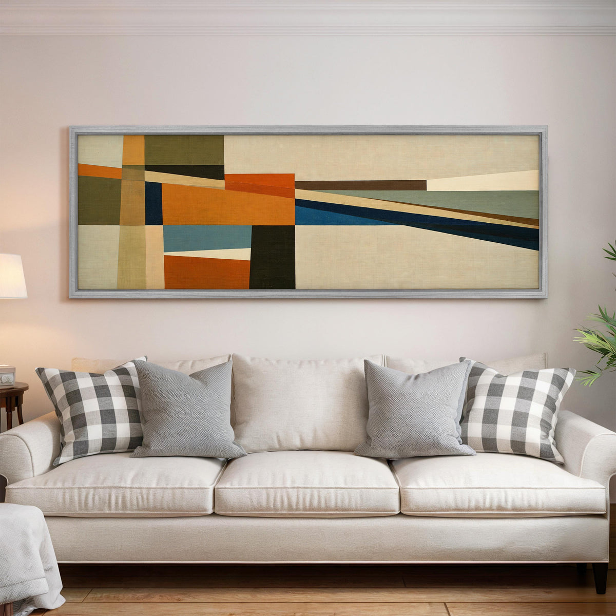 Olive and rust geometric blocks panoramic canvas print above a white sofa in a bright living room