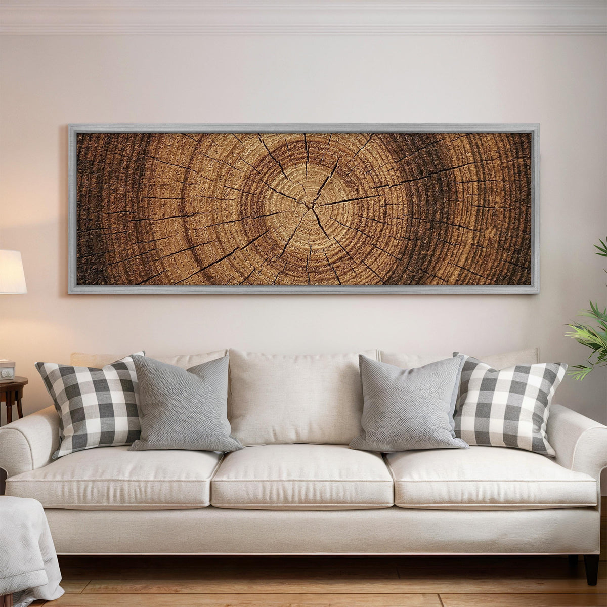 Warm oak wood ring panoramic canvas print above a white sofa in a bright living room