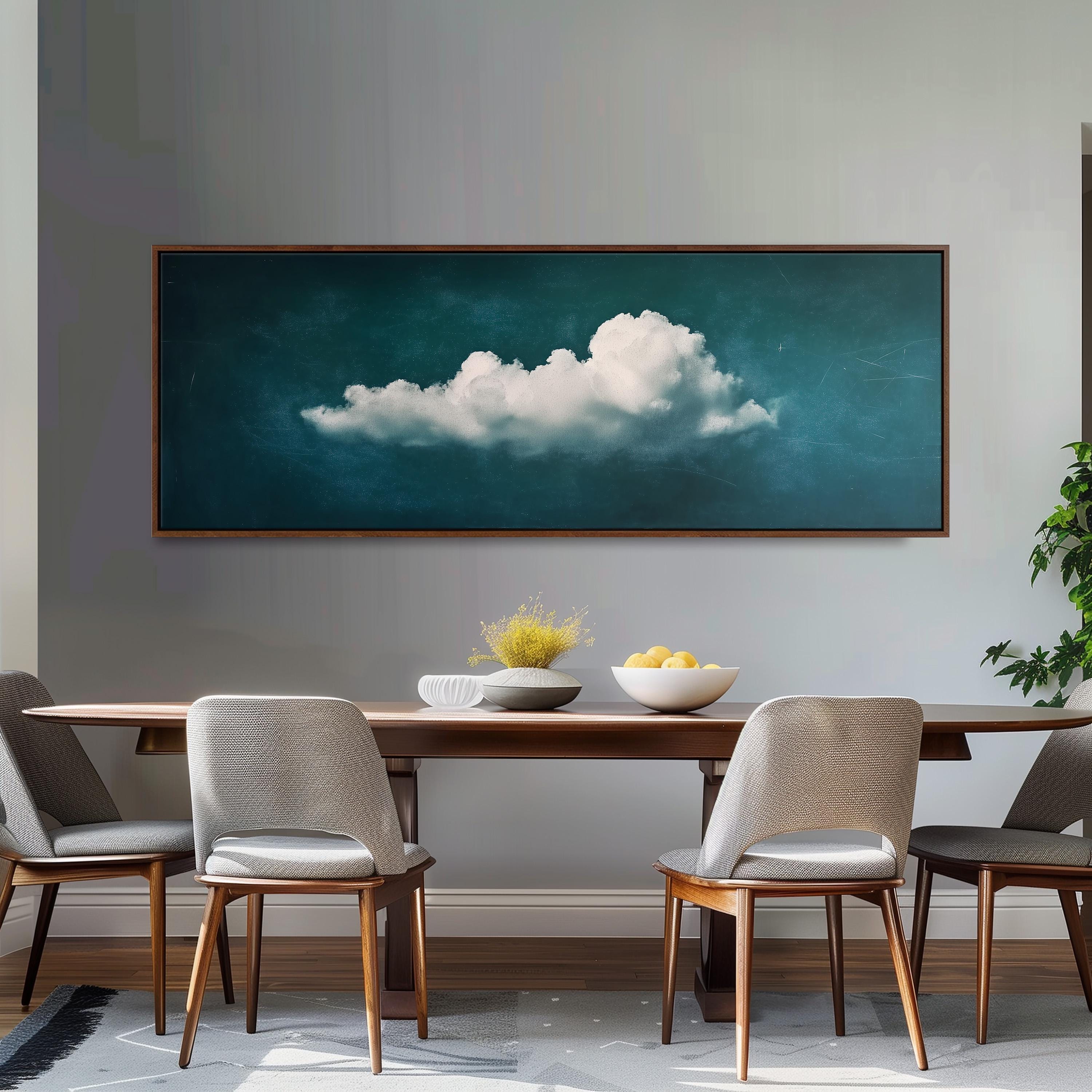 a dining room with a large framed painting of a cloud hanging on the wall above a wooden dining table with four chairs. The table is set with a bowl of fruit and a vase of flowers, creating a cozy and inviting atmosphere.