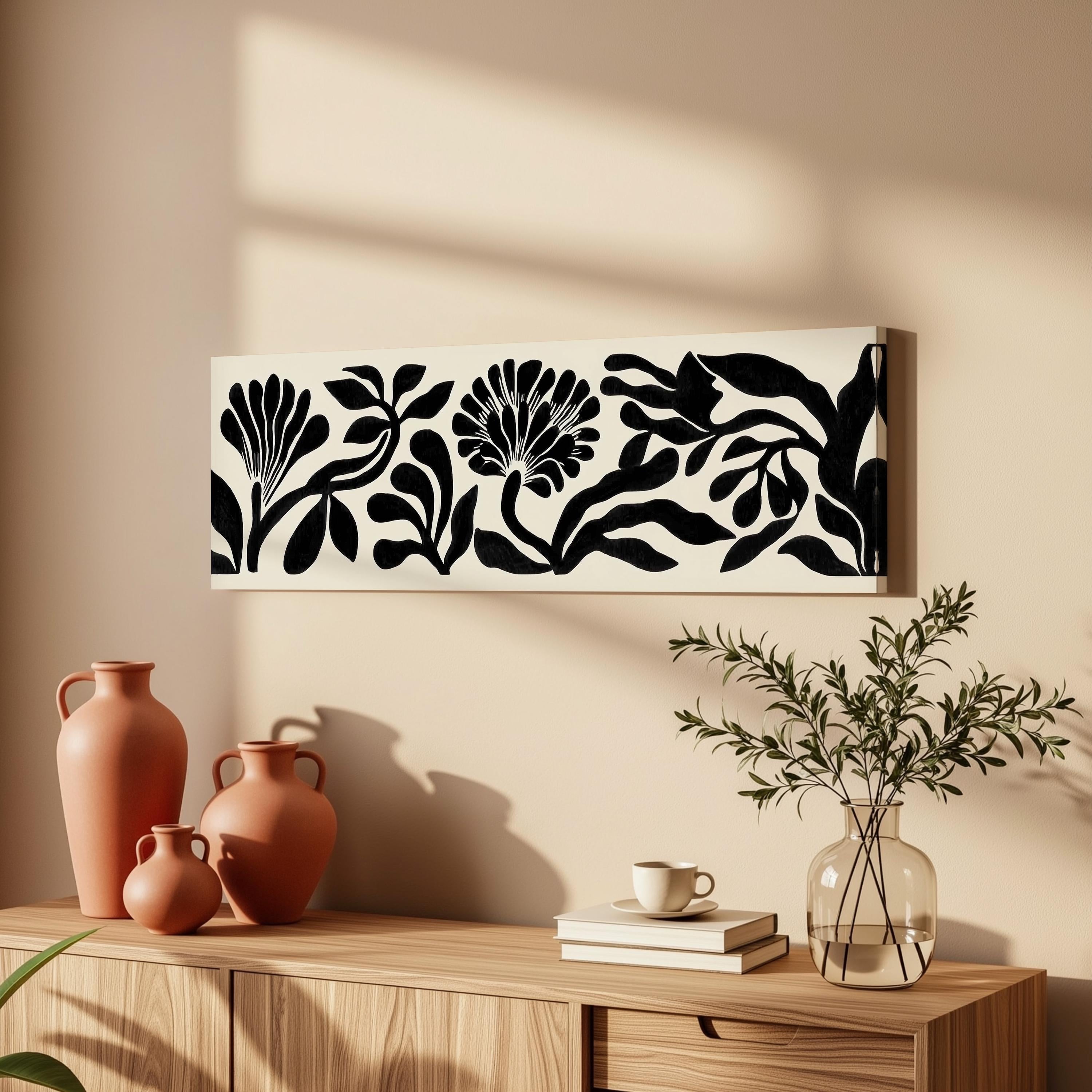 a wooden cabinet with a vase, a plant, and a framed artwork on the wall above it.