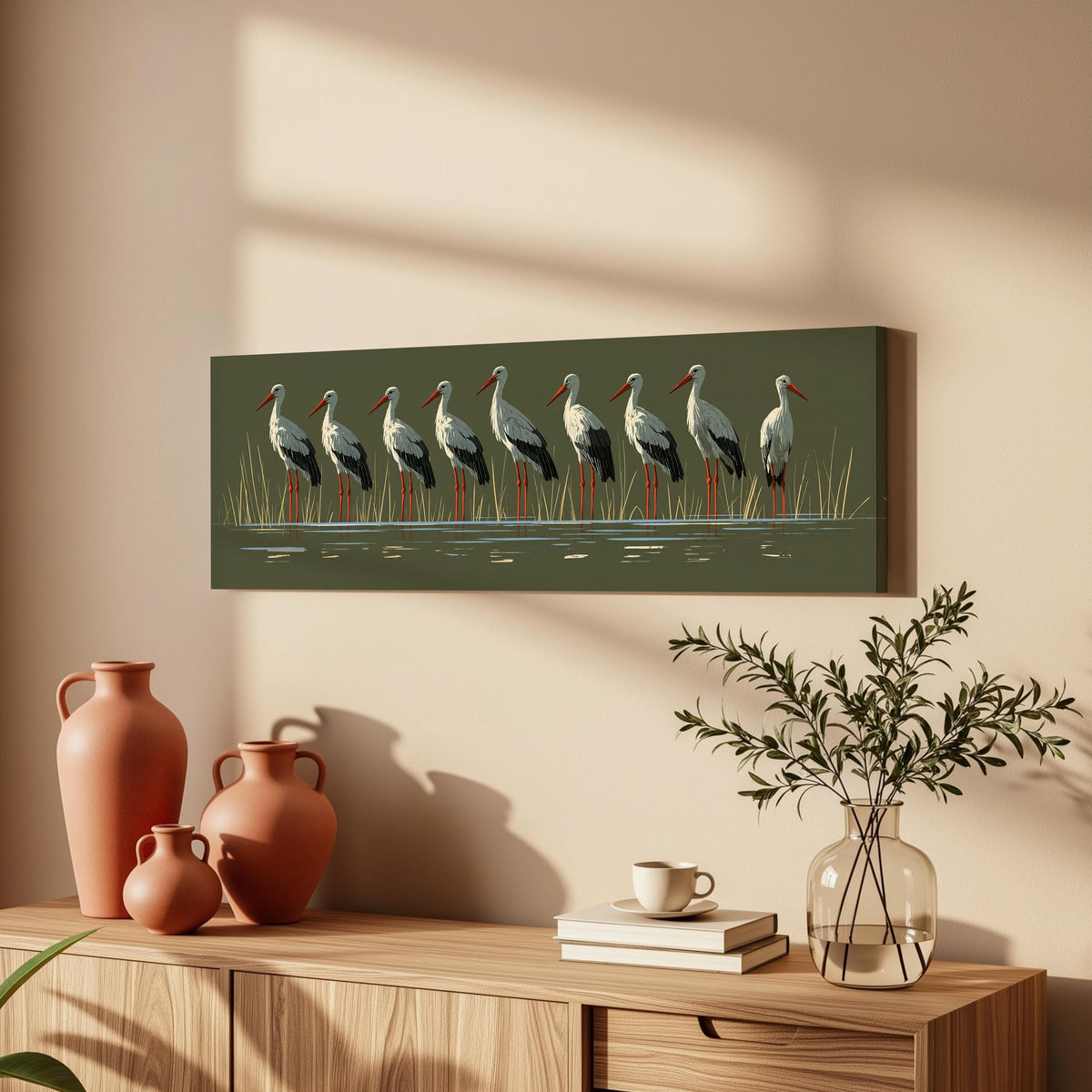 Flock of storks on olive green long horizontal canvas print above a wooden sideboard