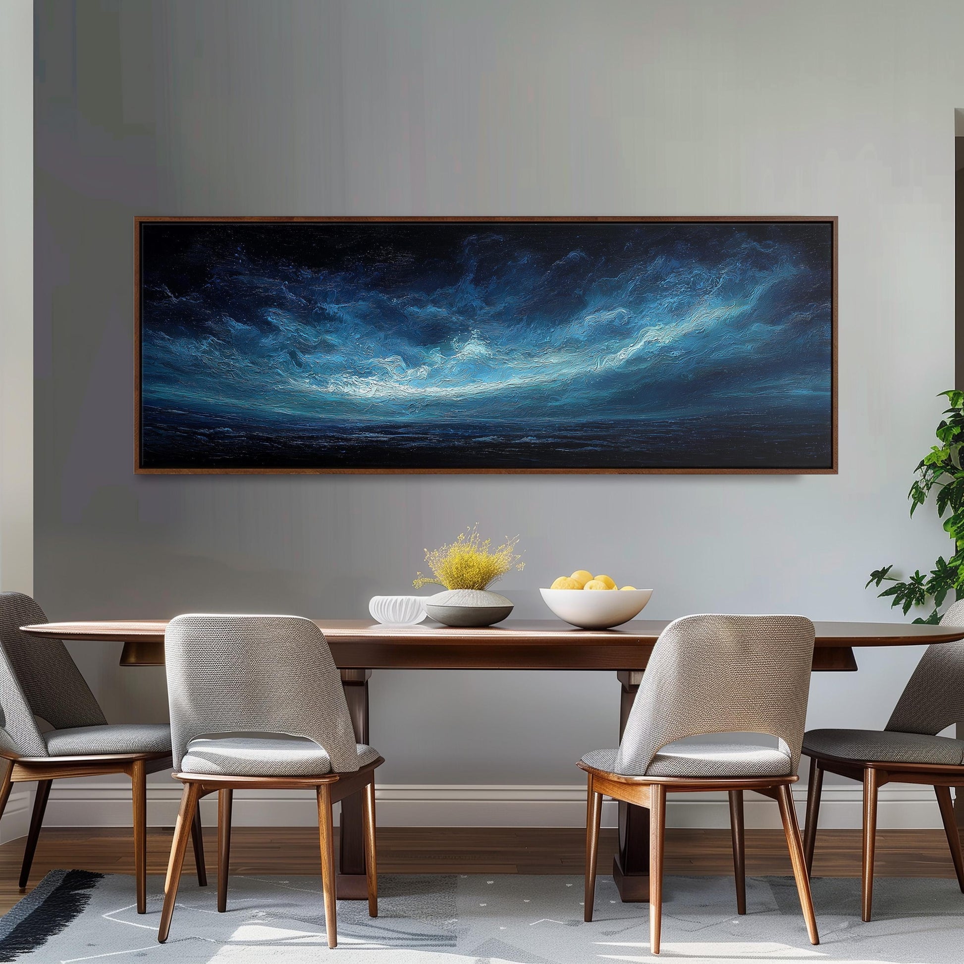 a dining room with a large painting of a stormy sky hanging on the wall above a wooden dining table with four chairs. The table is set with a bowl of fruit and a vase of flowers, creating a cozy and inviting atmosphere.
