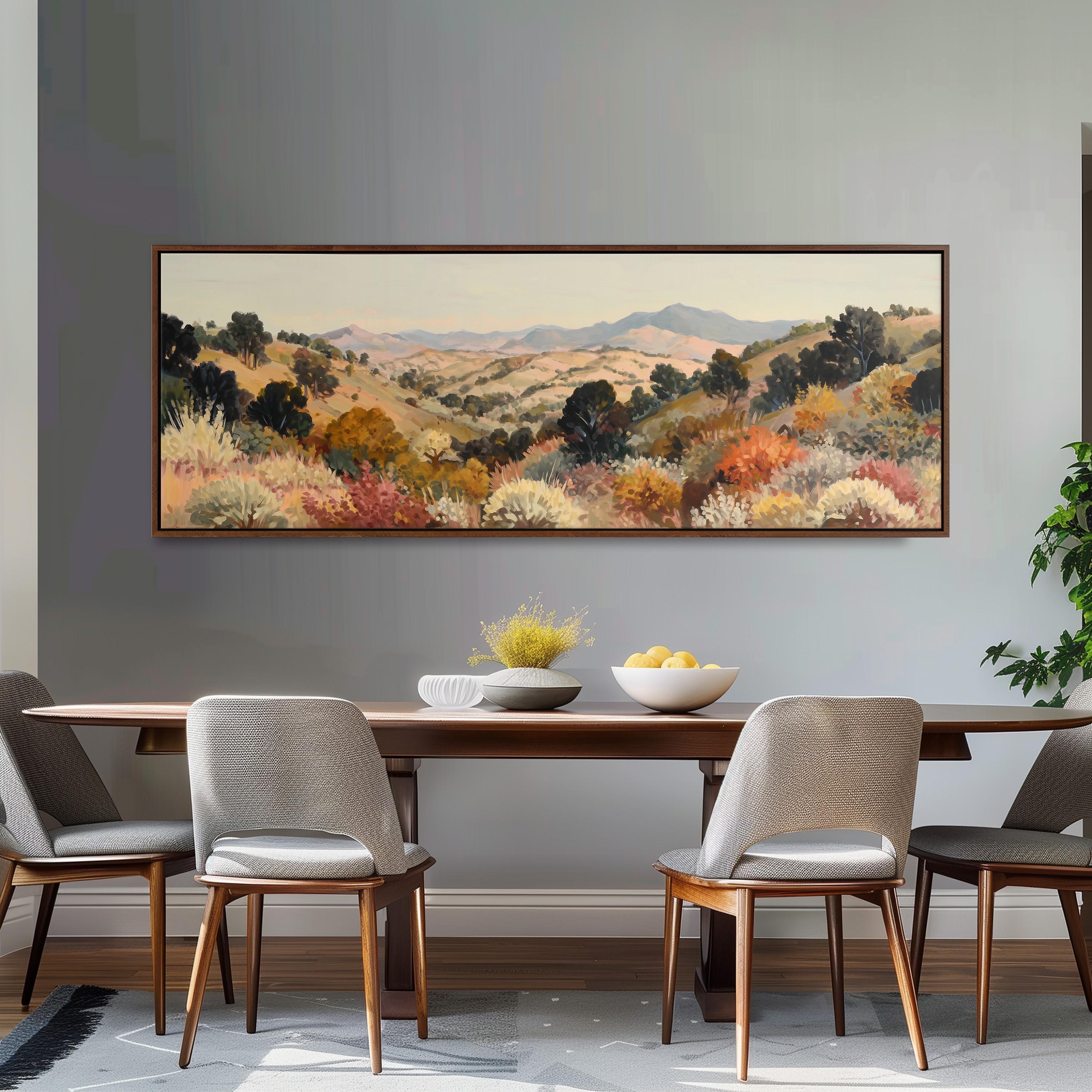 a dining room with a large painting of a countryside landscape hanging on the wall above a wooden dining table with four chairs. The table is set with a bowl of fruit and a vase of flowers, creating a cozy and inviting atmosphere.