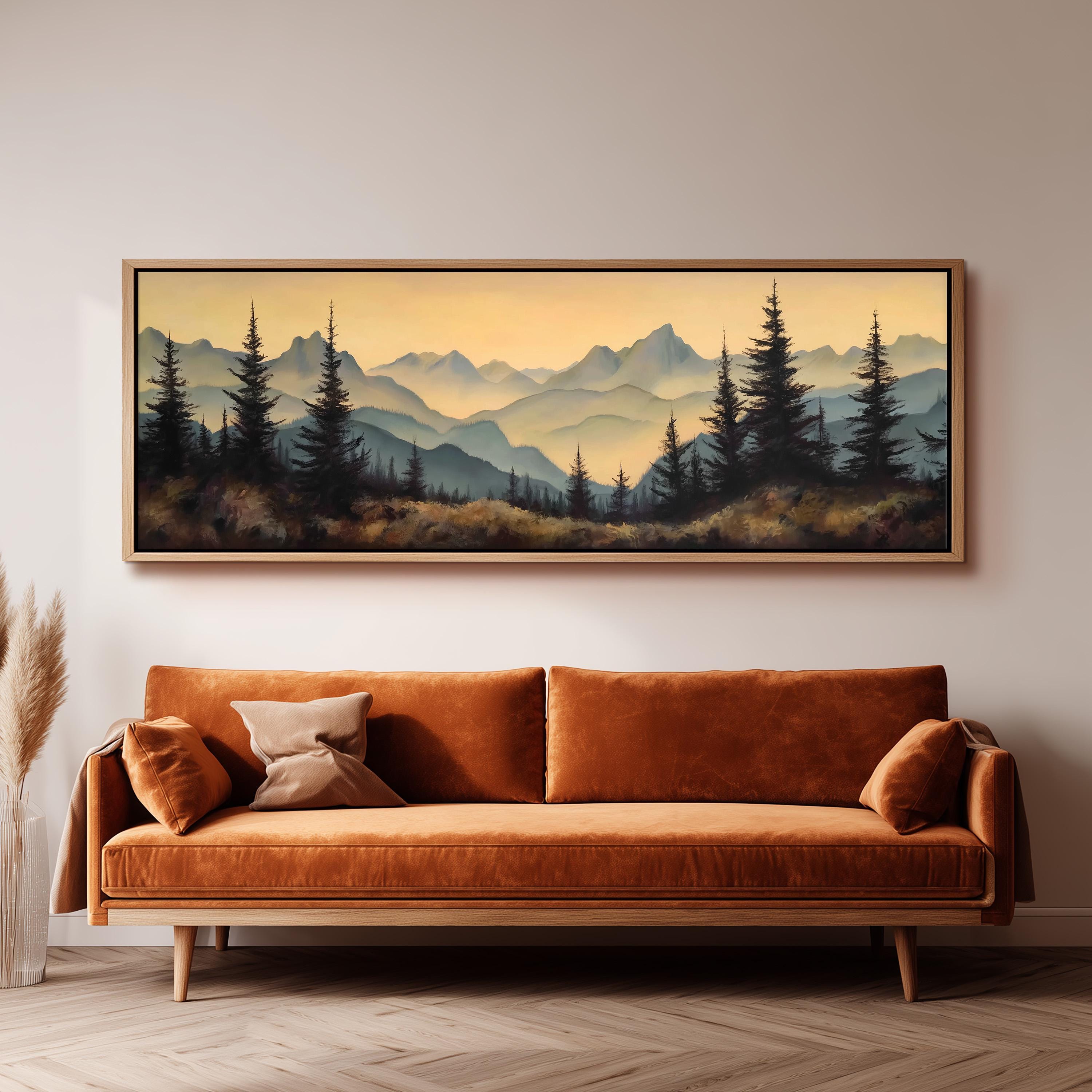 a large landscape painting hanging on a wall above a brown sofa with orange cushions.