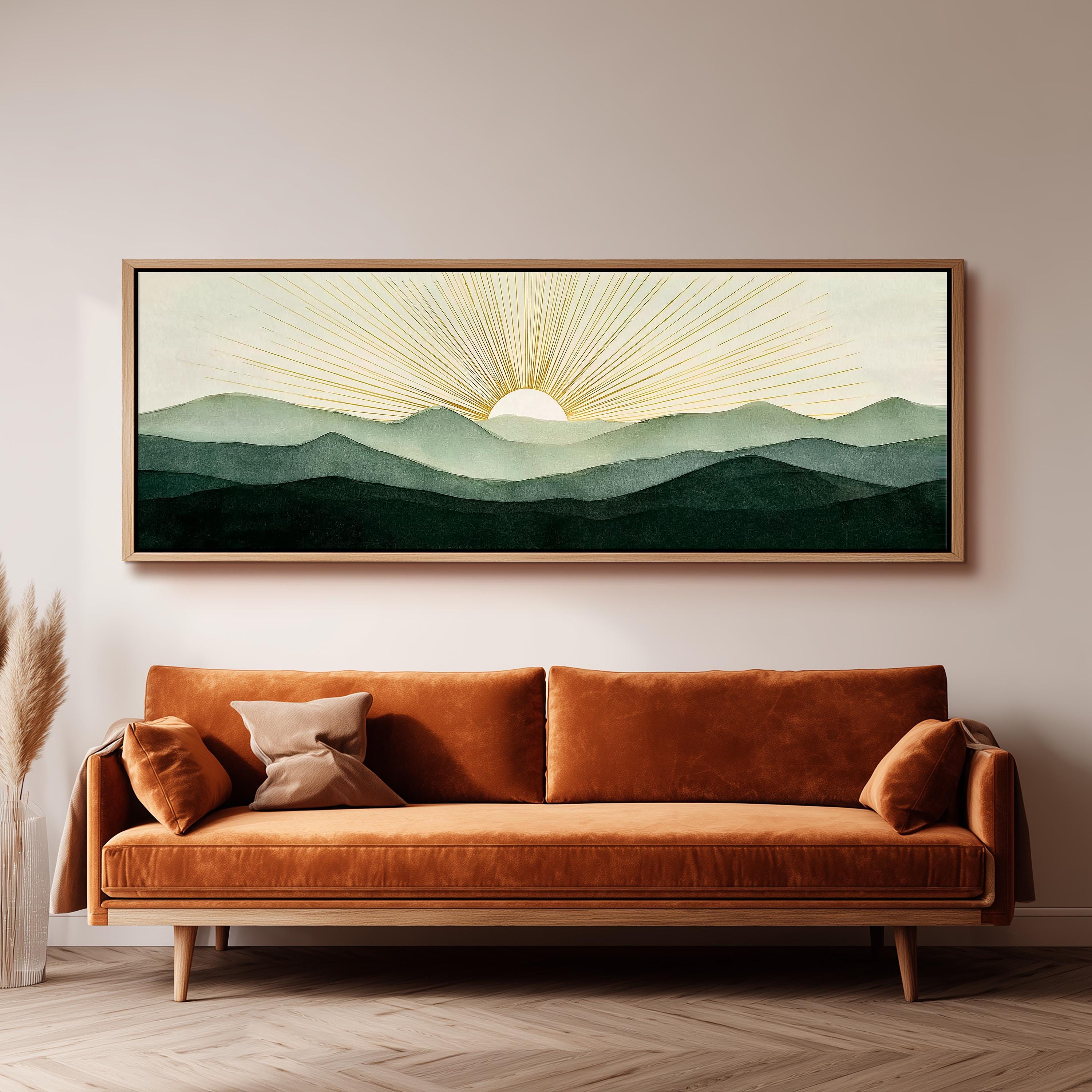 a large, framed painting of a sunrise over a mountain landscape, hanging on a wall above a brown sofa.