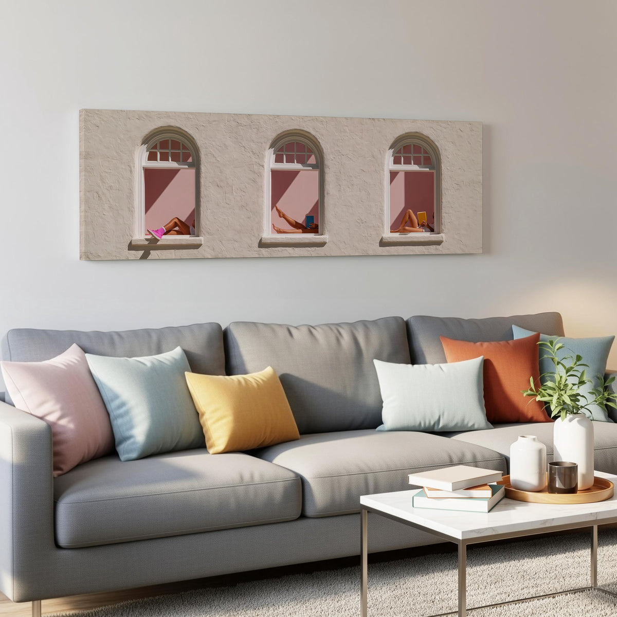 Women reading in three arched windows panoramic canvas print above a grey sofa in a living room
