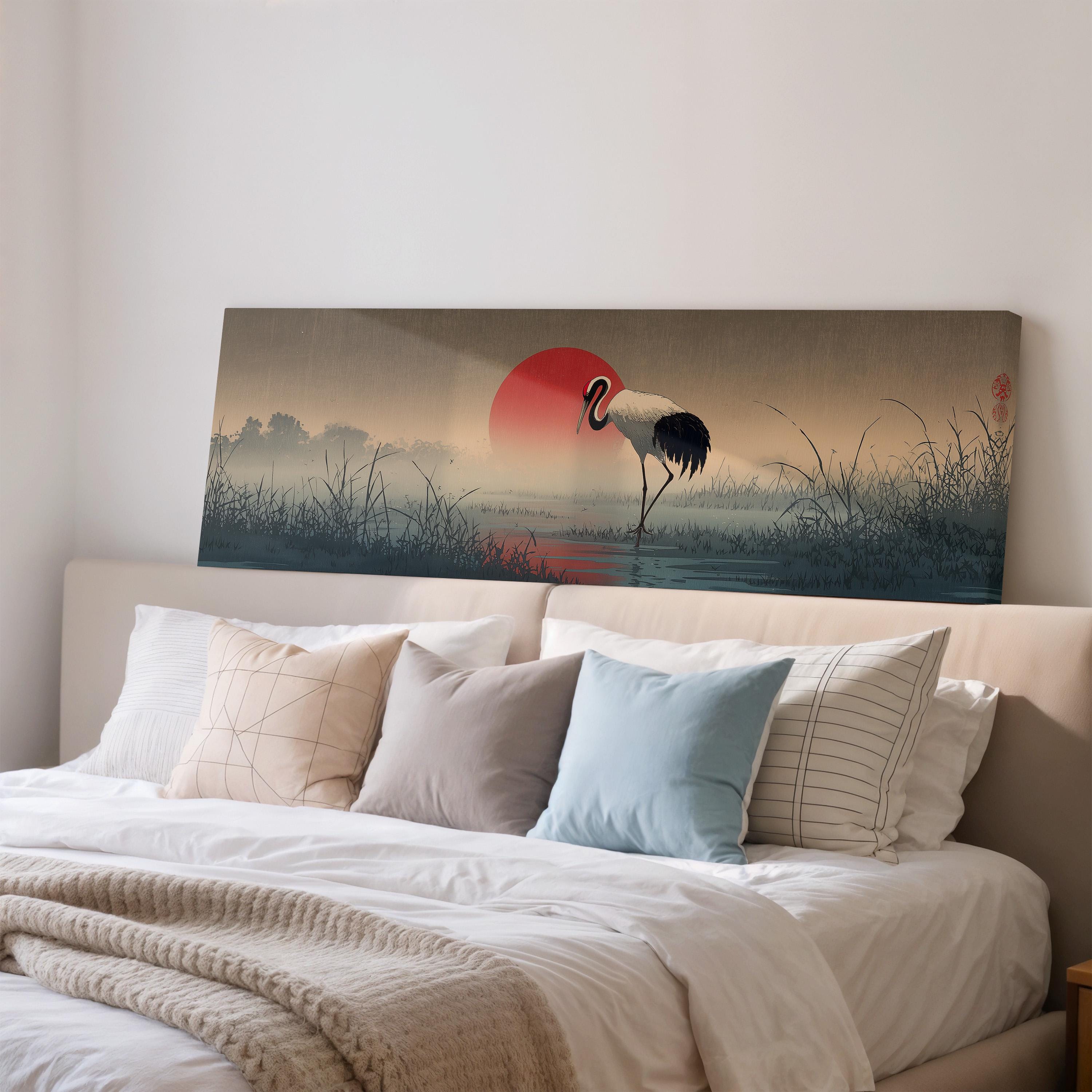 a large painting of a crane standing on a beach at sunset, with a red sun in the sky.