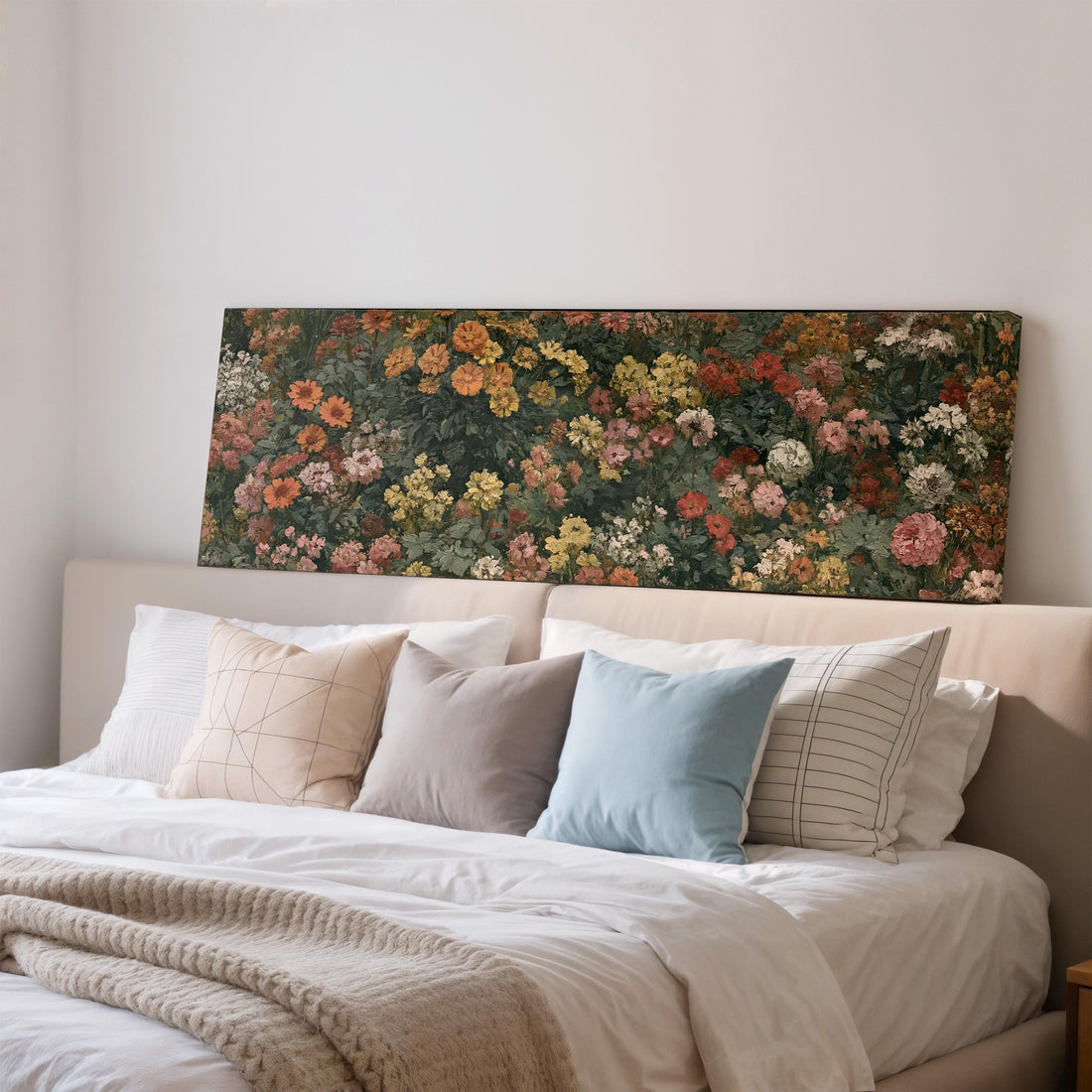 a dining room with a large floral painting hanging on the wall above a wooden table with four chairs. The table is set with a bowl of fruit and a vase of flowers, creating a cozy and inviting atmosphere.