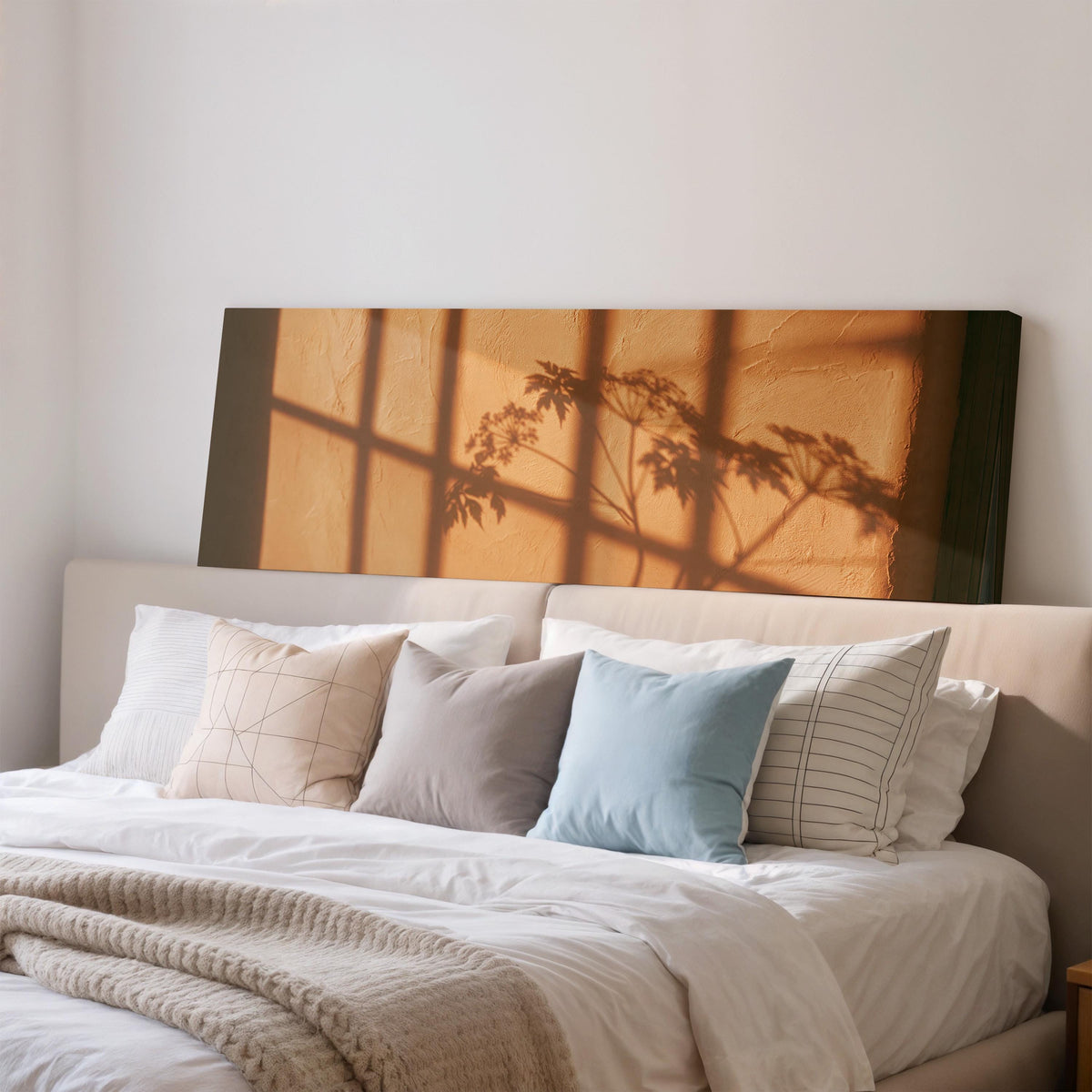 Plant and window shadows on a terracotta wall wide panoramic canvas print above a bed in a bedroom