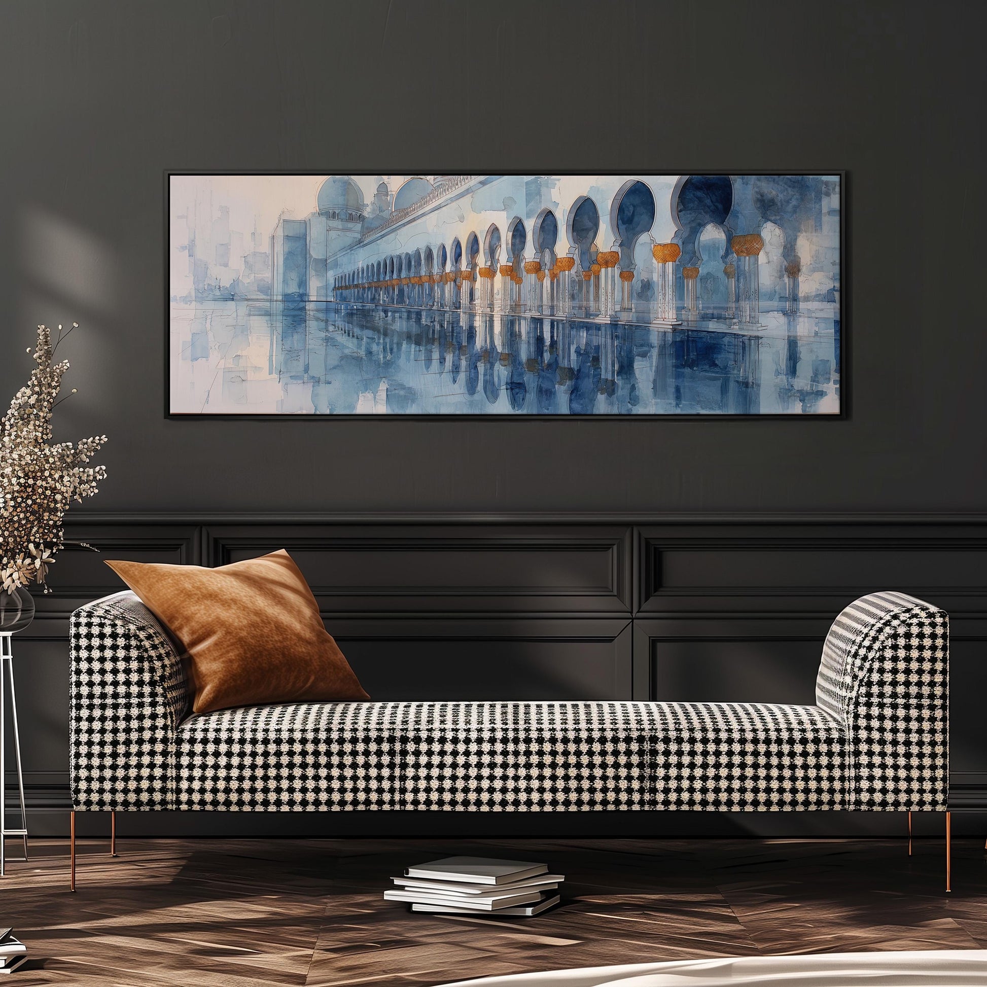 a large, rectangular painting of a building with arches hanging on a wall above a black and white checkered sofa with a brown throw pillow.