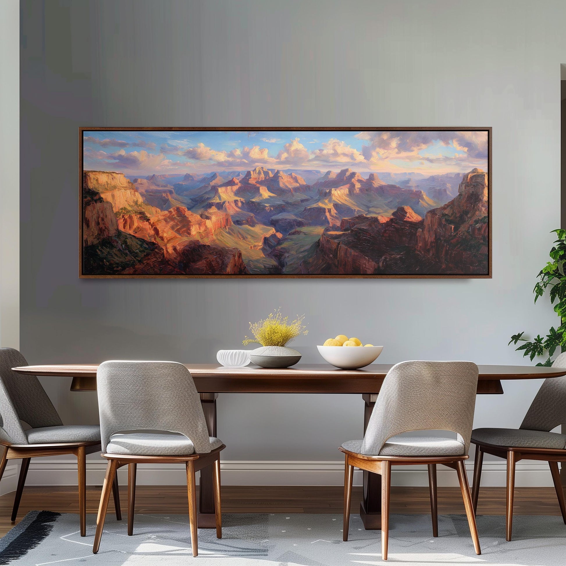 a large painting of a mountainous landscape hanging on a wall above a wooden dining table with four chairs.