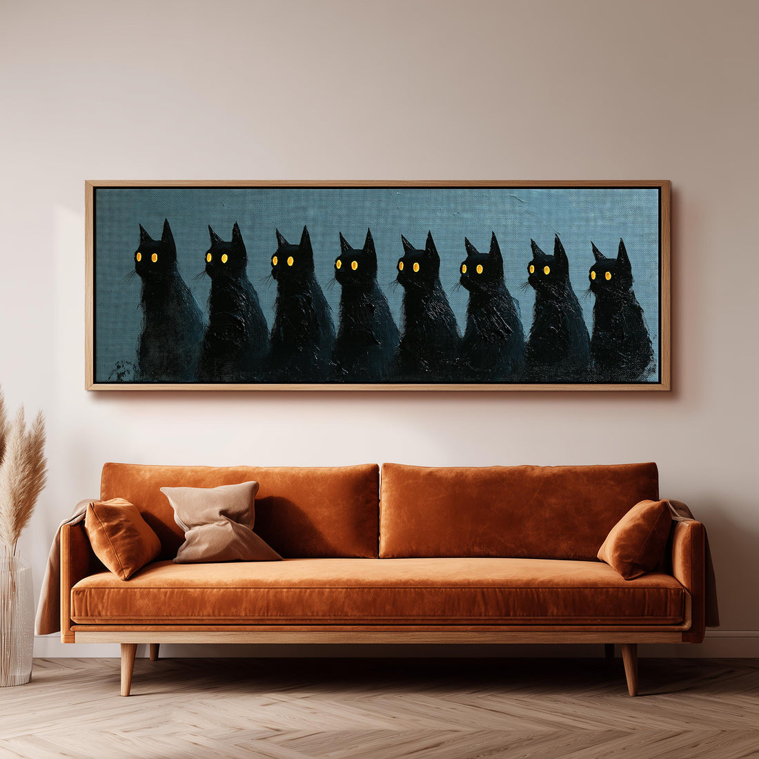 Row of black cats with glowing eyes long horizontal canvas print above a sofa in a living room