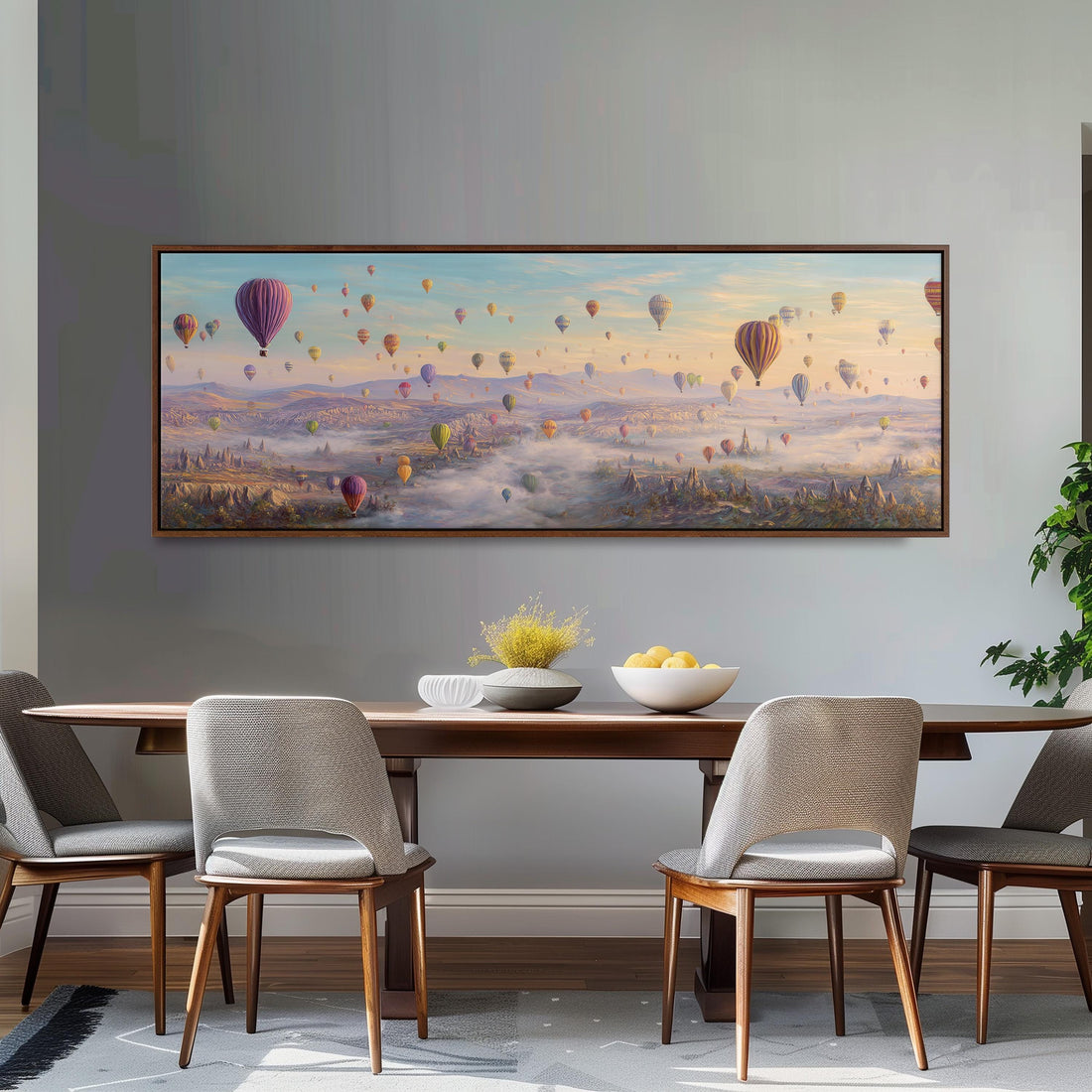a large painting of hot air balloons floating in the sky above a cityscape, with a bowl of fruit and a plant on a table in the foreground.