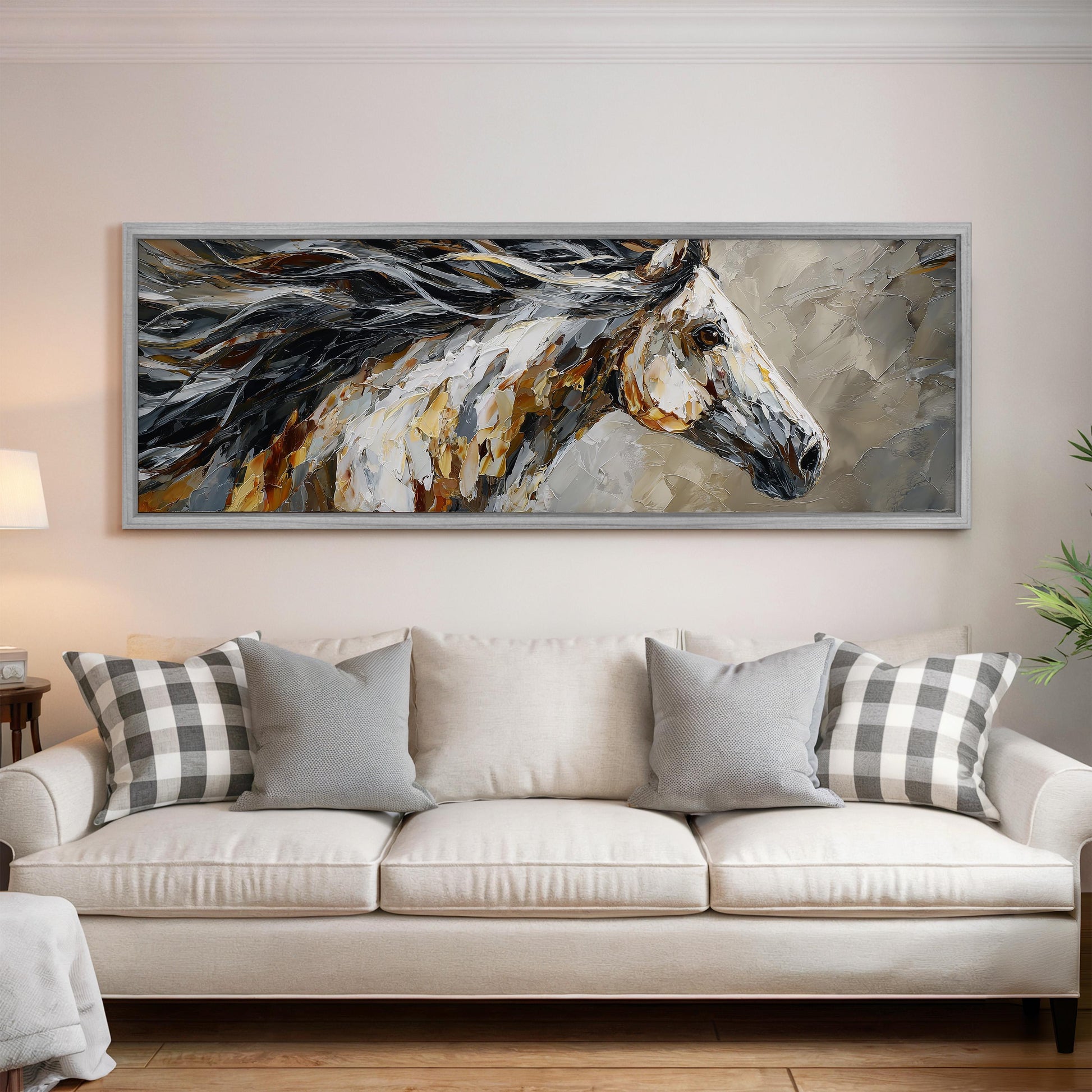 a large, framed painting of a horse's head hanging on a wall above a white couch with gray and white plaid throw pillows.