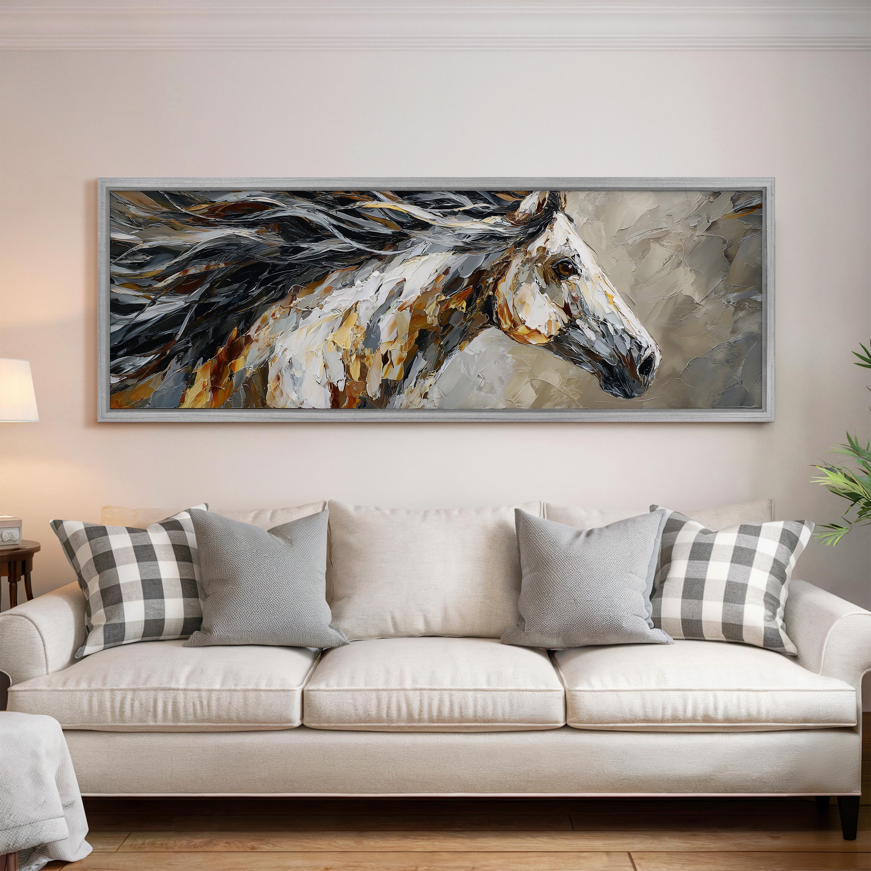 a large, framed painting of a horse's head hanging on a wall above a white couch with gray and white plaid throw pillows.
