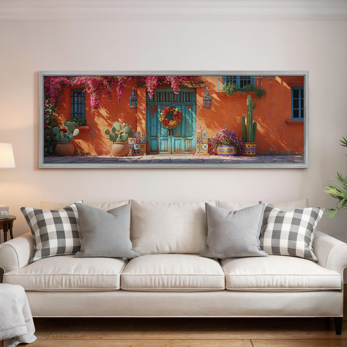 Adobe doorway with a wreath and cacti panoramic canvas print above a white sofa in a bright living room
