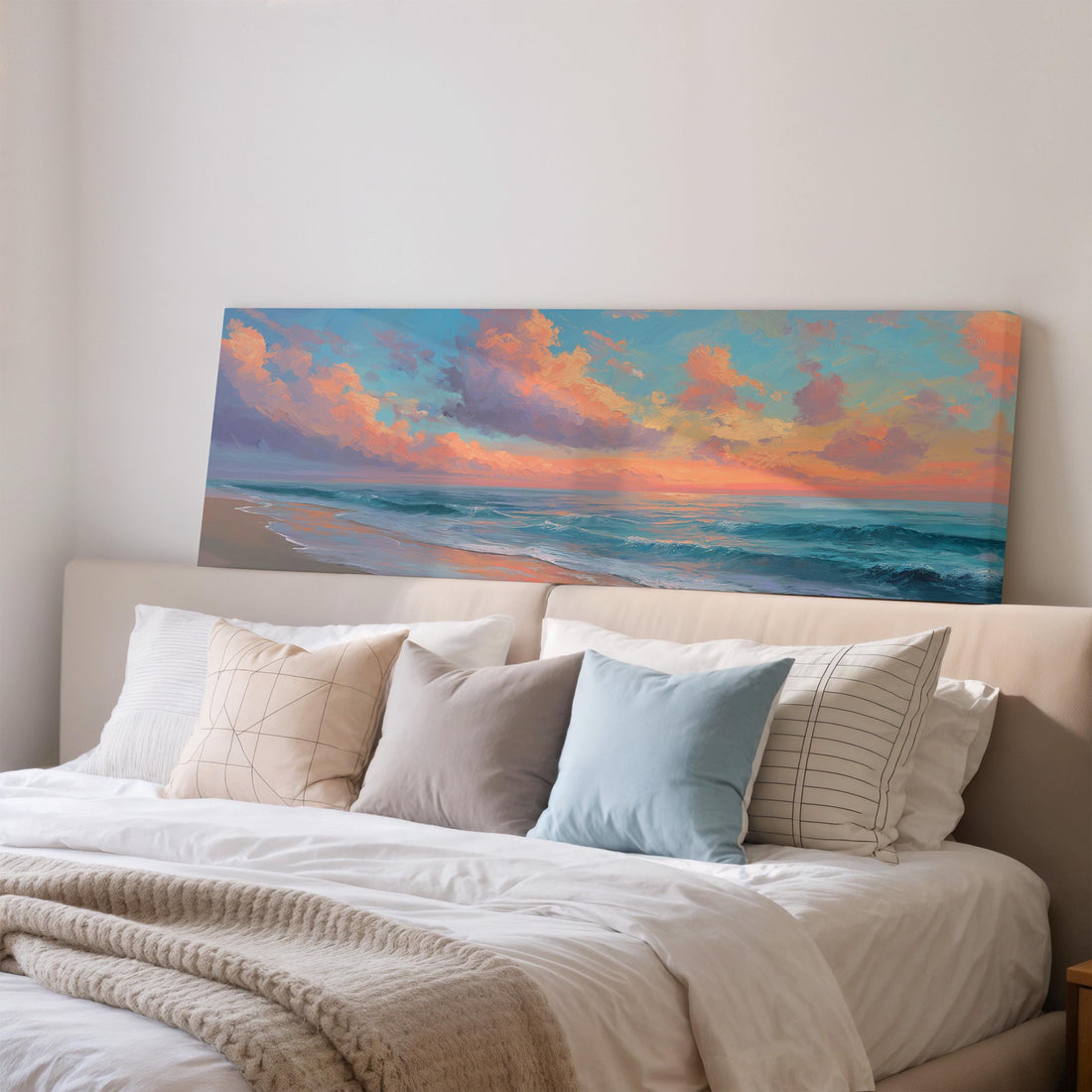 a large, rectangular painting of a beach scene hanging on a wall above a black and white checkered sofa.