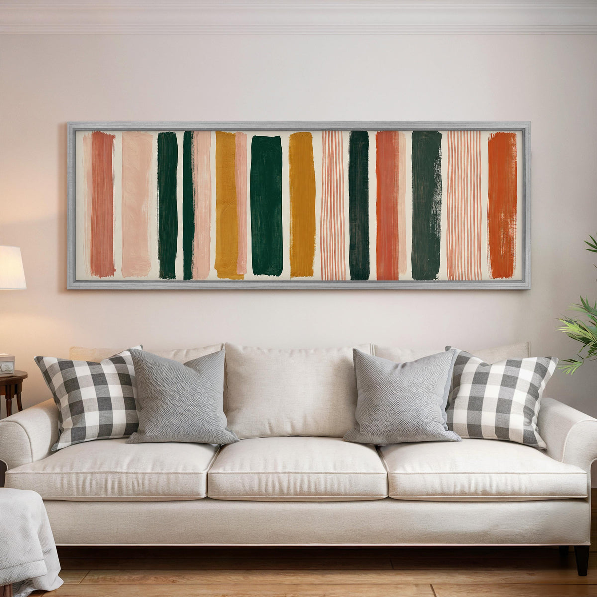 Mixed stripe blocks in terracotta, pink and green panoramic canvas print above a white sofa in a bright living room