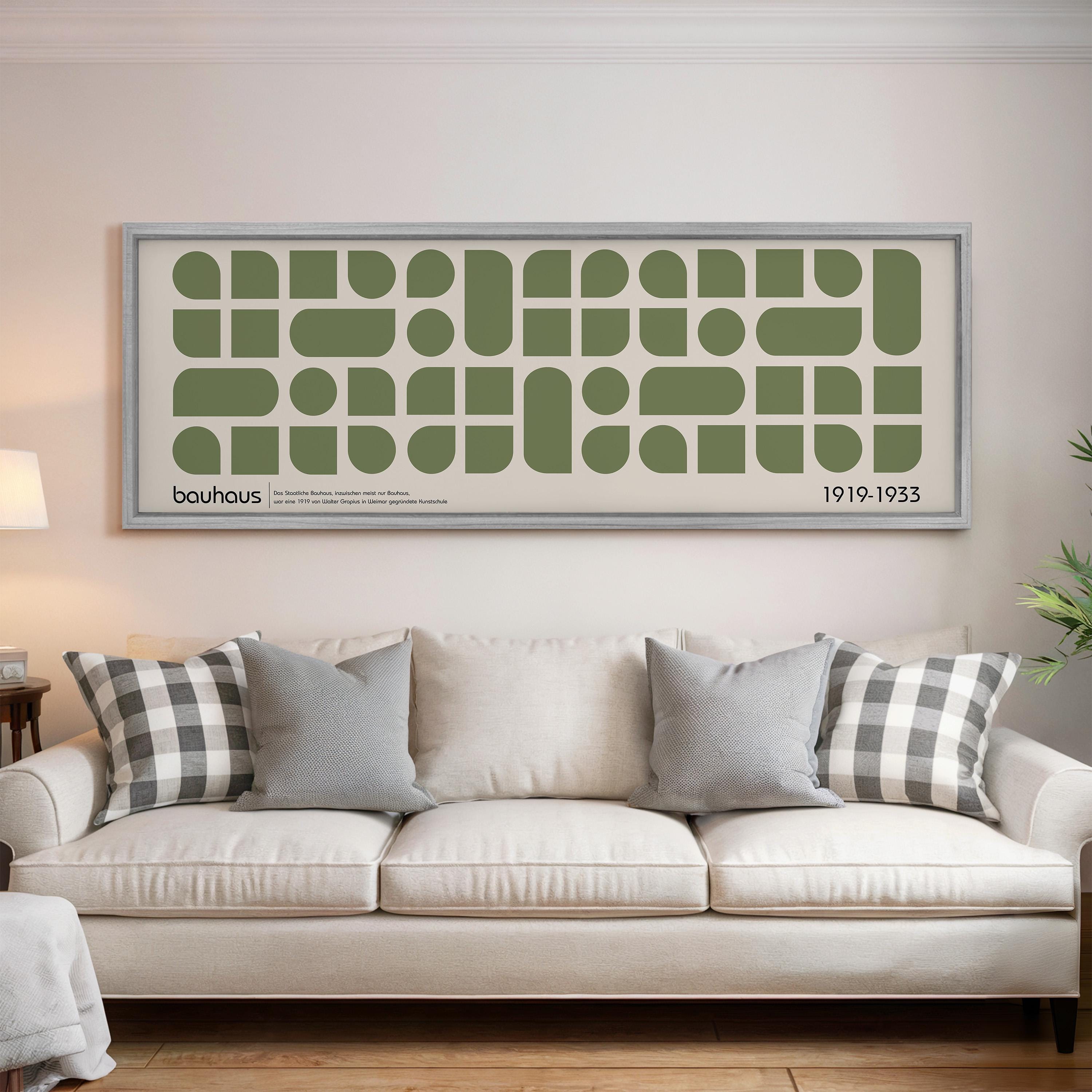 a large framed poster of a repeating geometric pattern on a wall above a white sofa with patterned throw pillows.