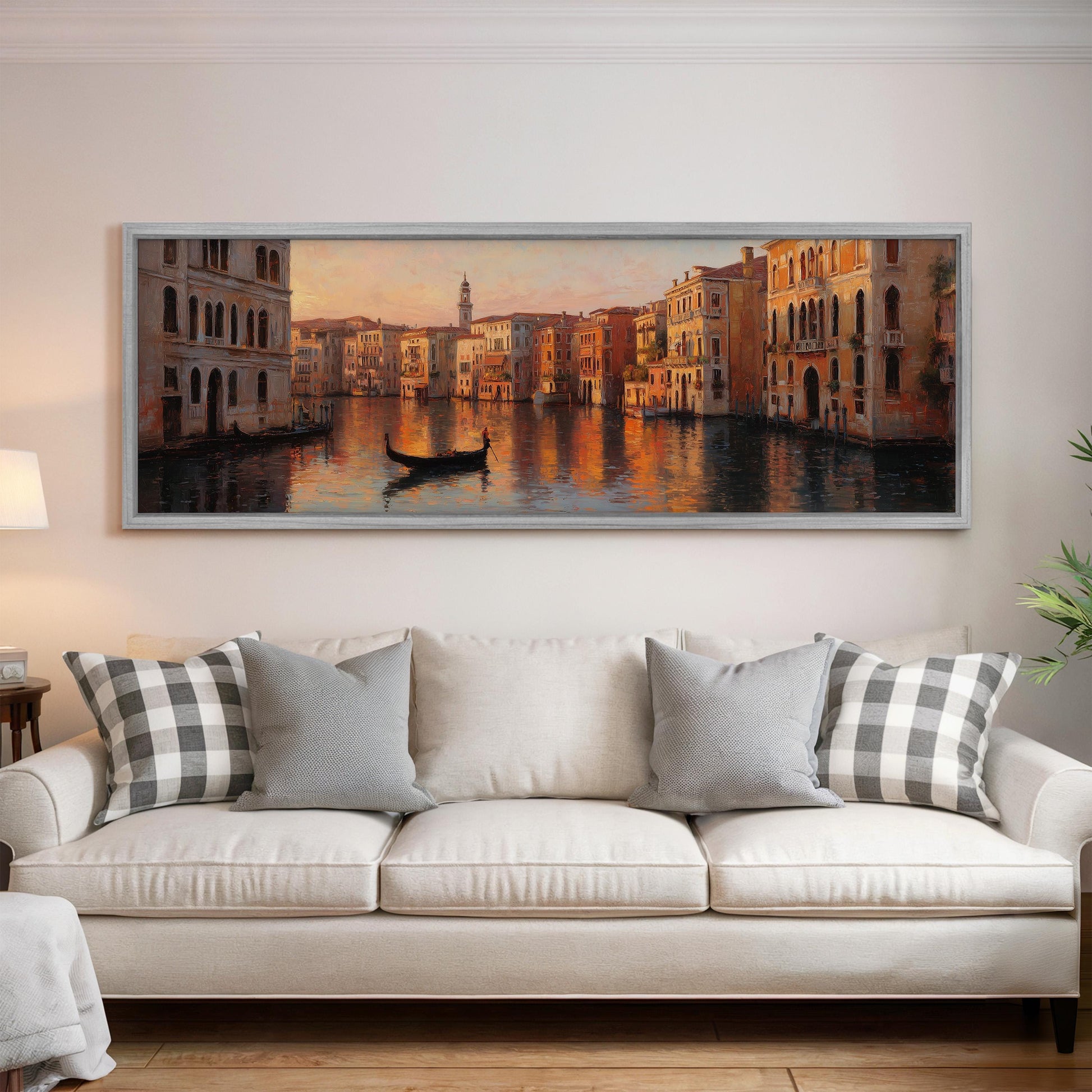 a large painting of a cityscape with a gondola in the foreground, hanging on a wall above a white sofa with patterned throw pillows.