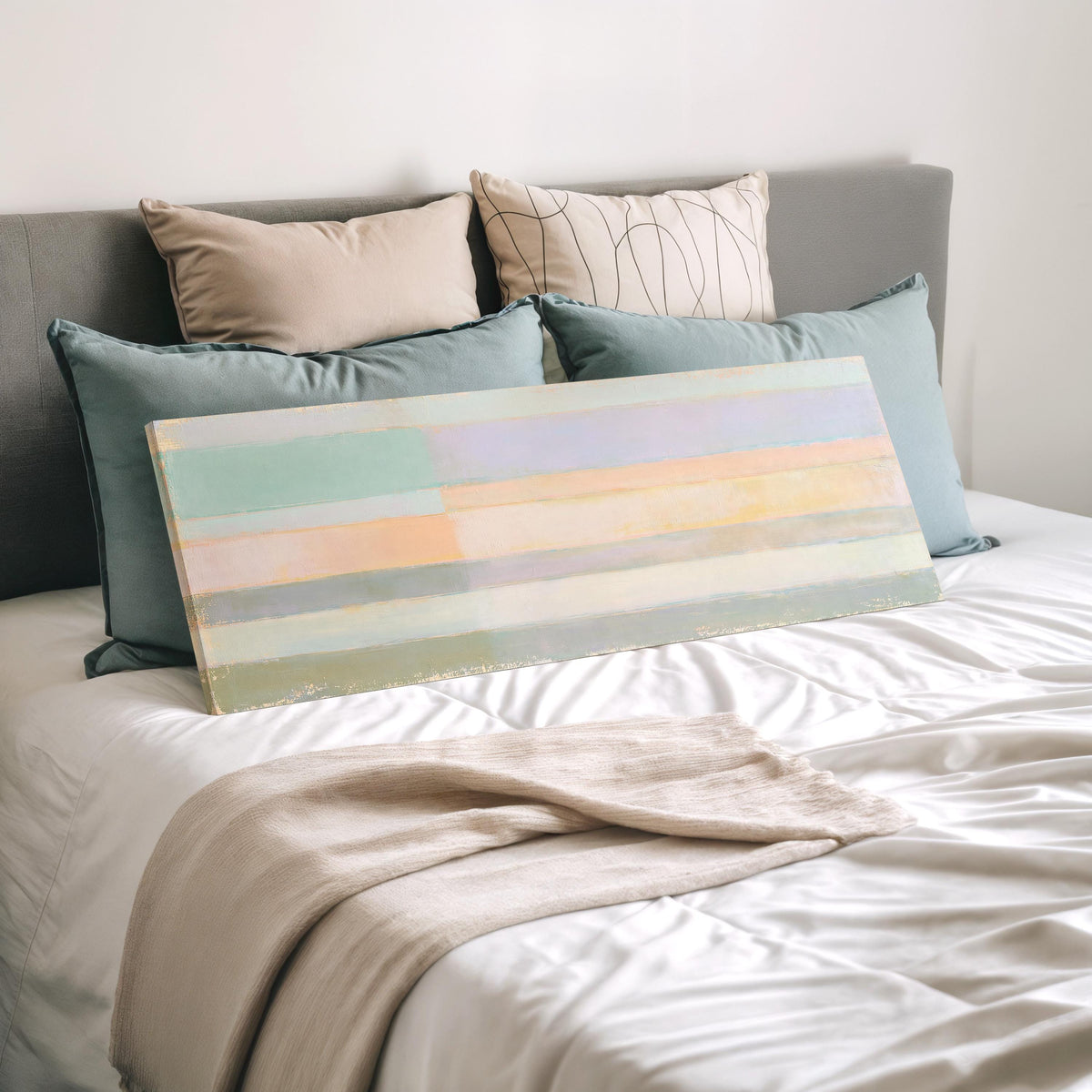 Mint, lavender and peach pastel bands wide panoramic canvas print laid on a bed to show its size