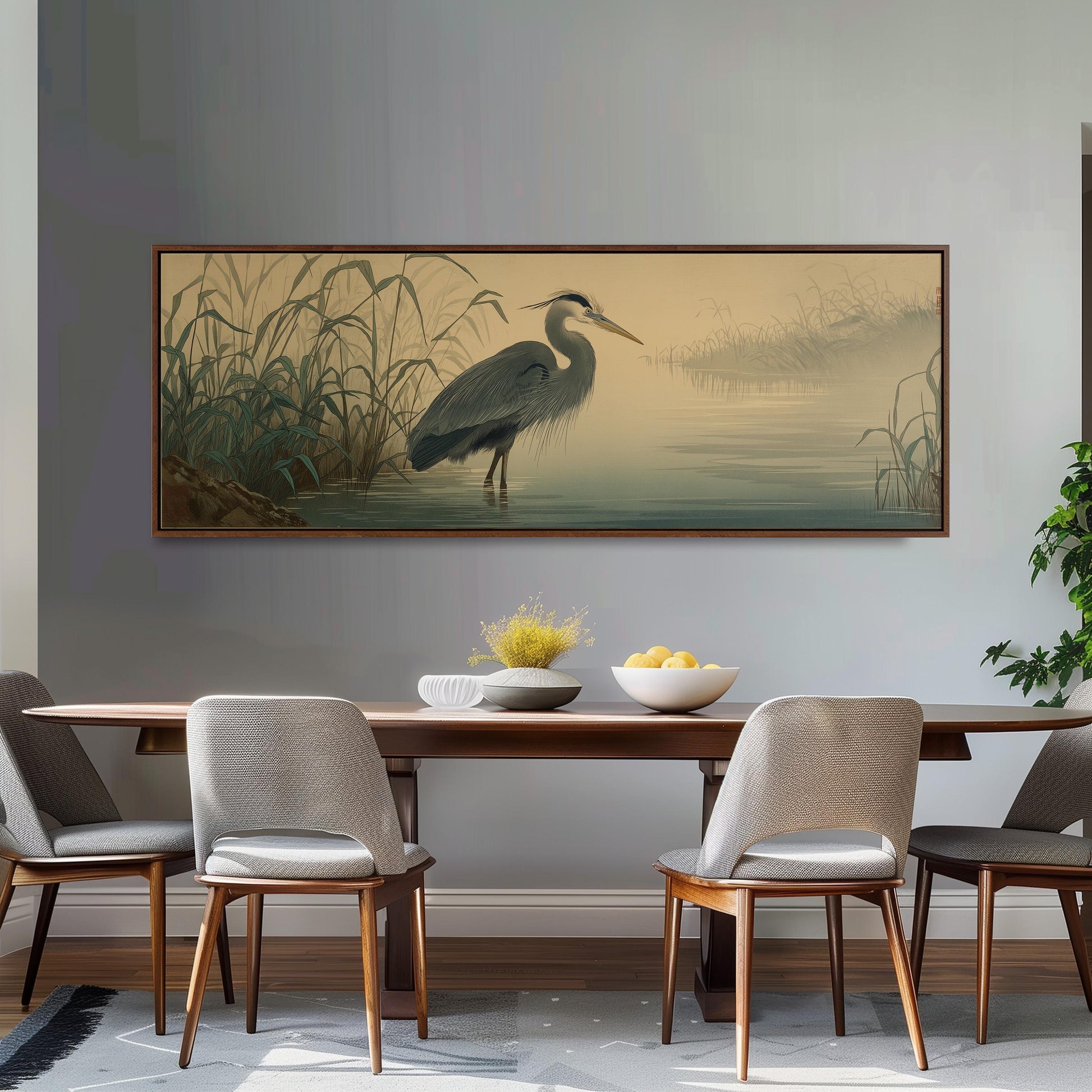 a dining room with a large painting of a heron standing in a body of water on the wall above a wooden dining table with four chairs.