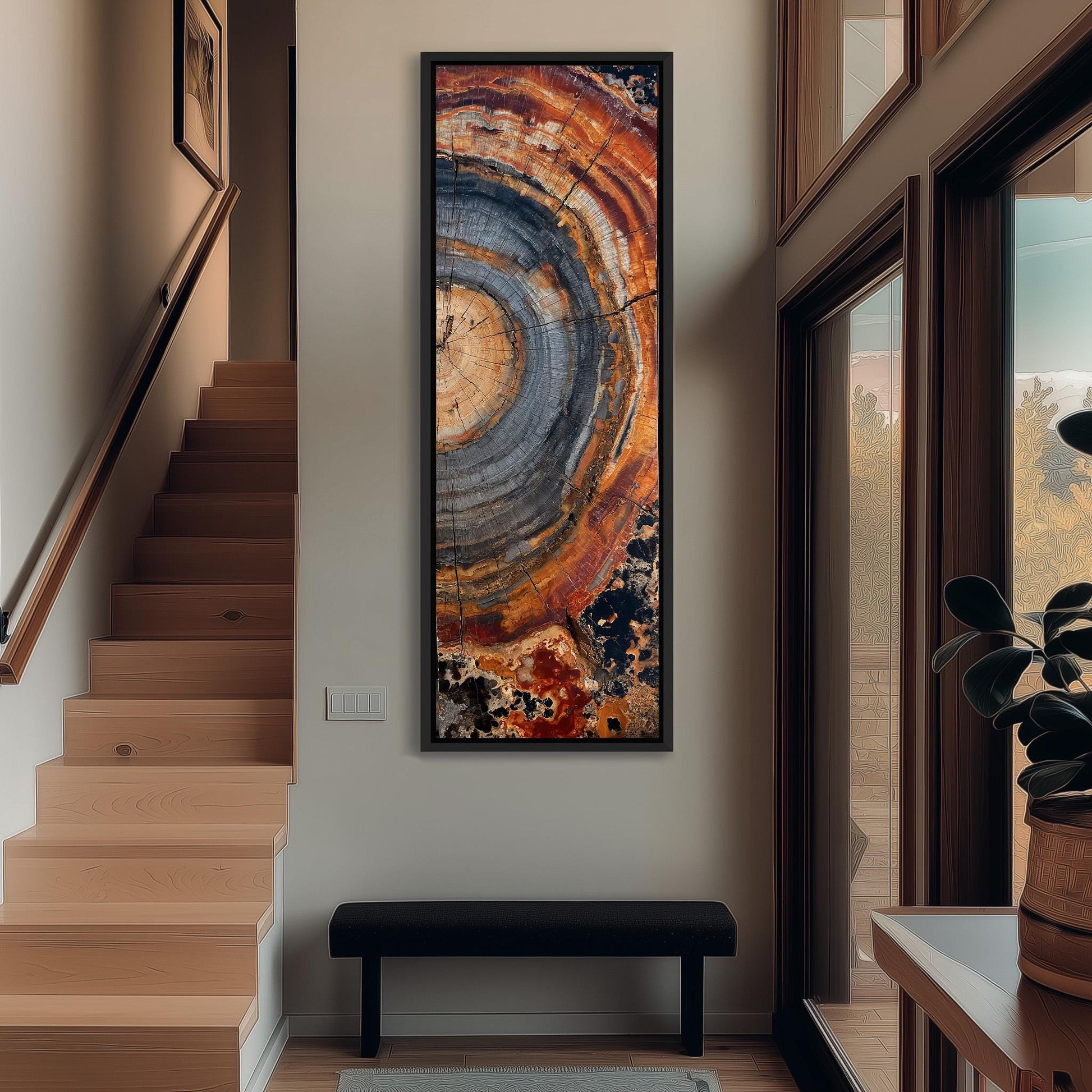 a hallway with a large abstract painting hanging on the wall, a wooden staircase, a black bench, and a plant in a pot.
