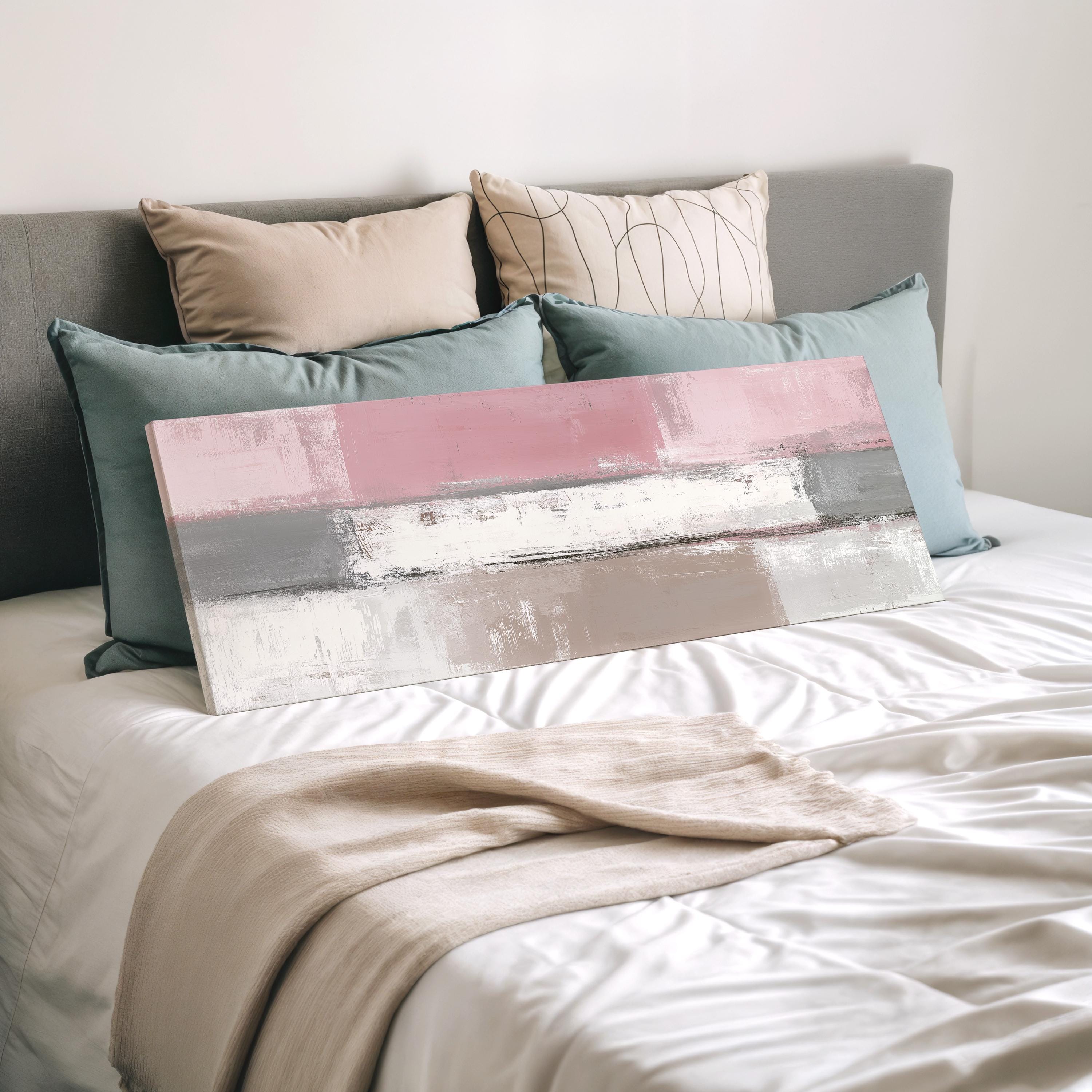 a bedroom with a bed covered in white sheets and a large abstract painting resting on top of the bed.