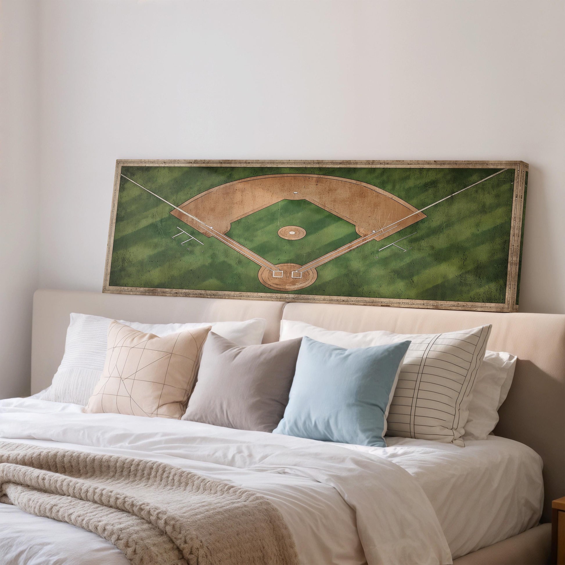 a bedroom with a large framed picture of a baseball field on the wall above a bed with white pillows and a gray blanket.