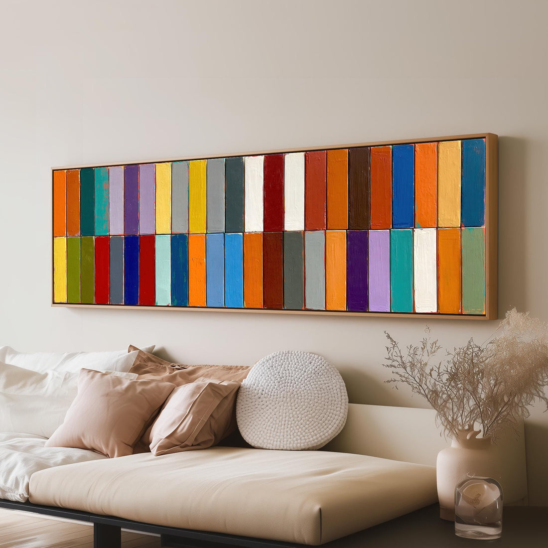 Two rows of colorful stripe blocks long horizontal canvas print above a sofa in a living room