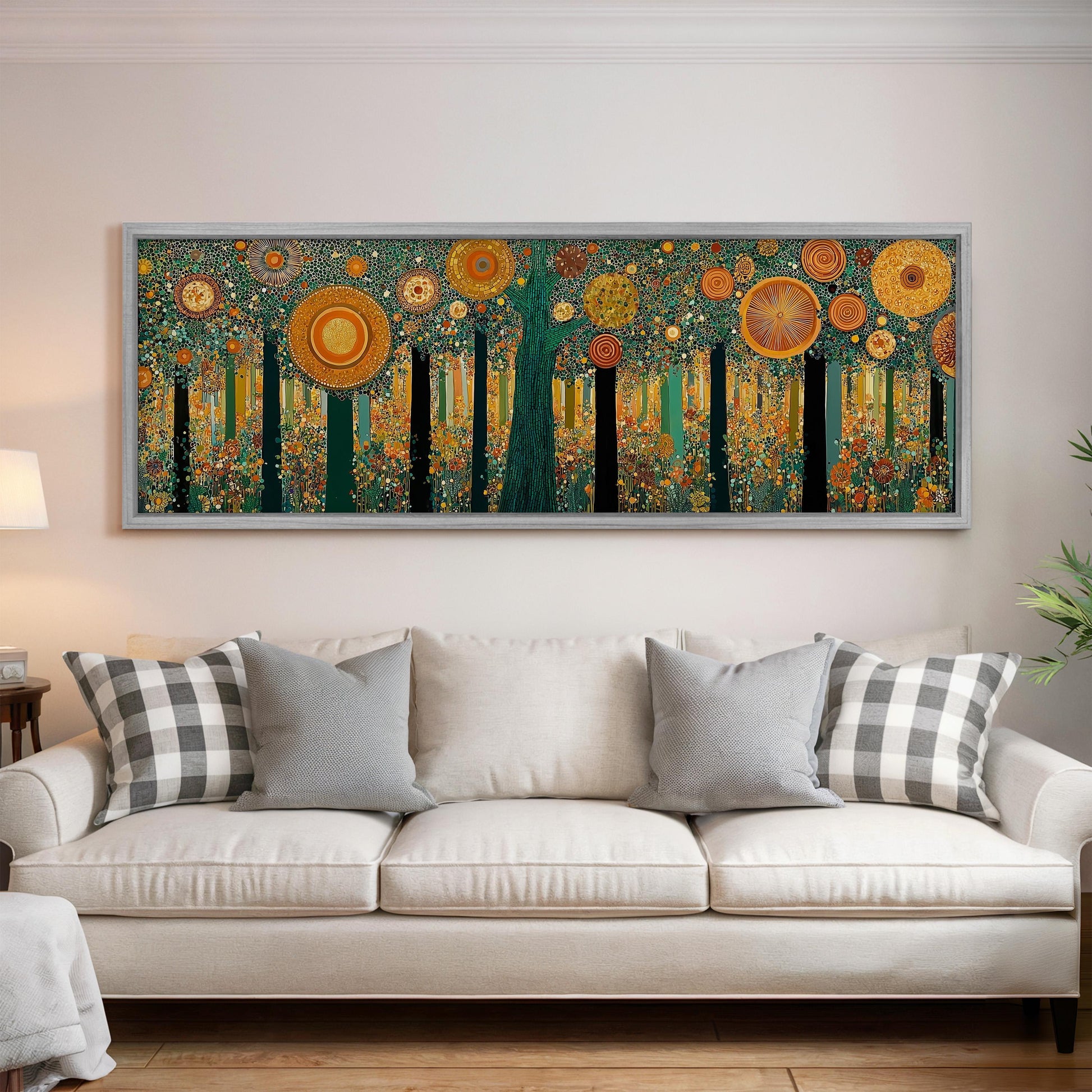 a large, colorful painting of a forest scene hanging on a wall above a white couch with gray and white plaid throw pillows.