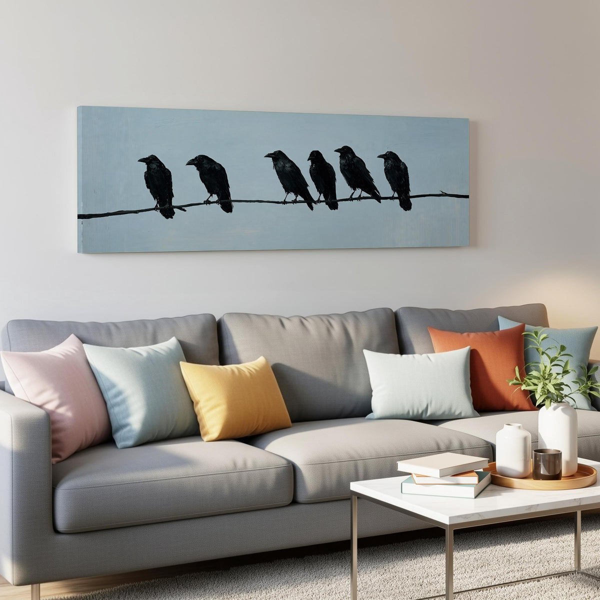 Ravens spaced along a wire panoramic canvas print above a grey sofa in a living room