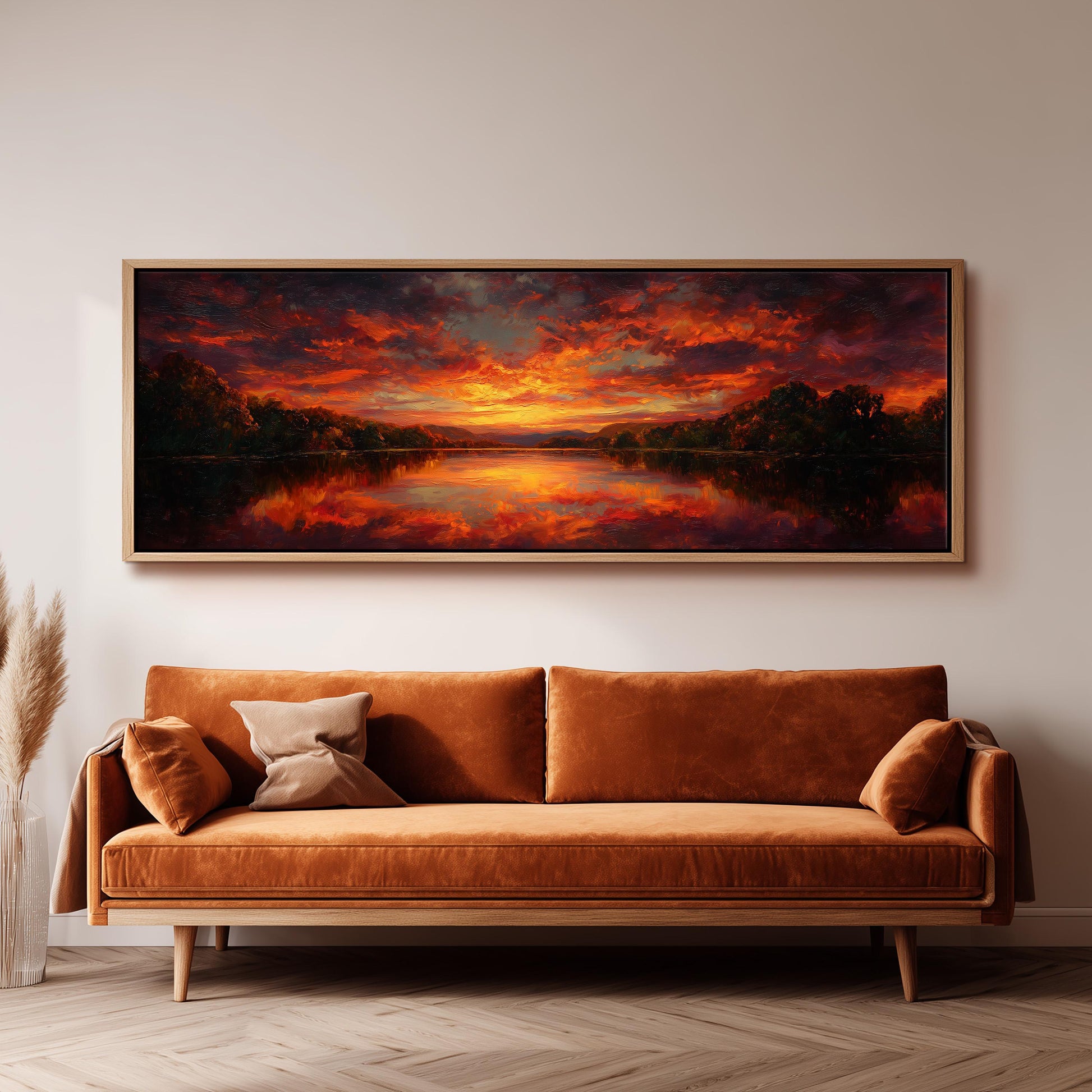 a large, framed painting of a sunset landscape hanging on a wall above a brown sofa.