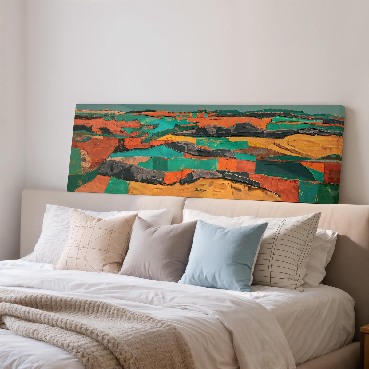 Abstract patchwork terrain in orange and teal wide panoramic canvas print above a bed in a bedroom