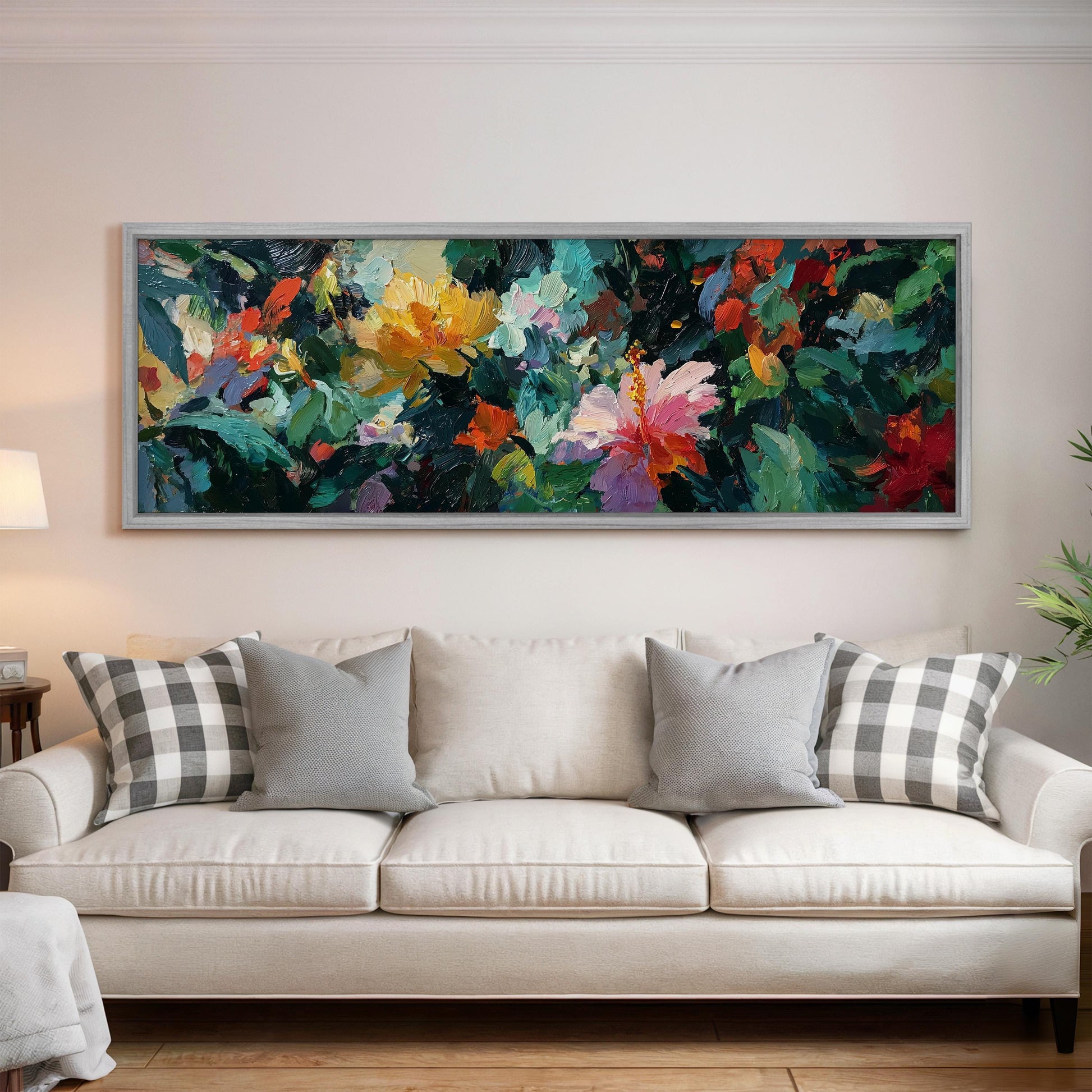 a large, colorful painting of flowers hanging on a wall above a white couch with gray and white plaid throw pillows.