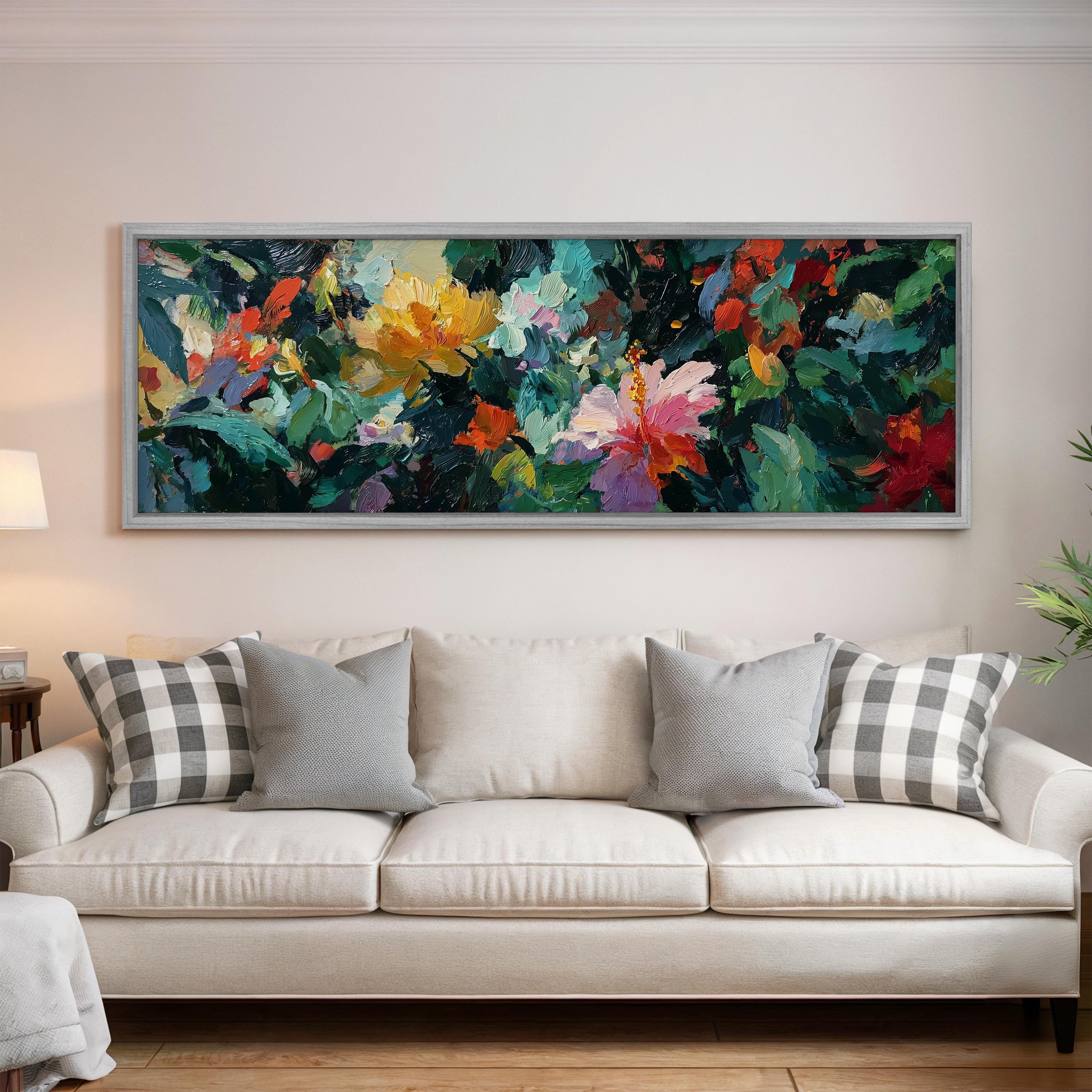 a large, colorful painting of flowers hanging on a wall above a white couch with gray and white plaid throw pillows.