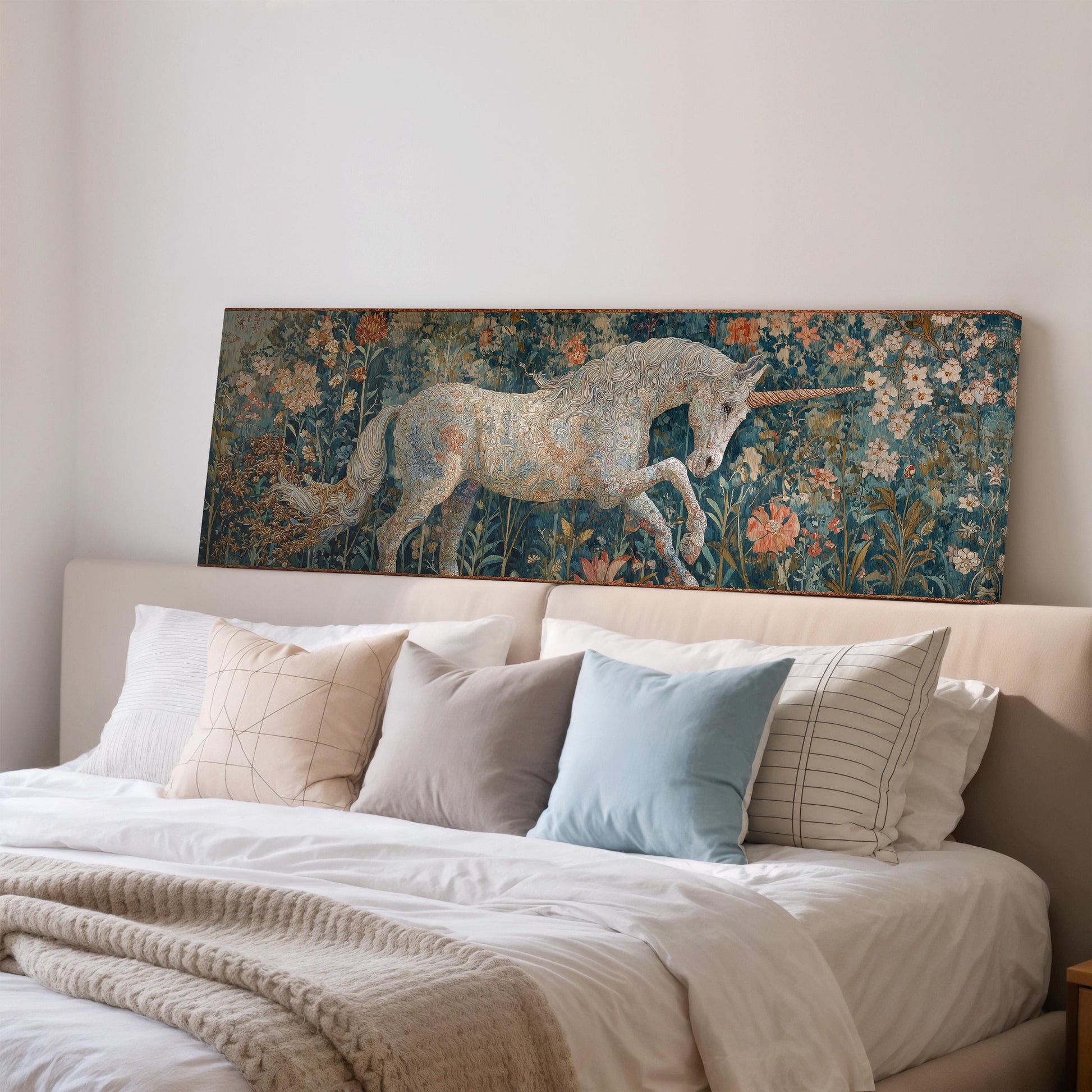 a large painting of a unicorn on a wall above a bed with white pillows and a blanket.