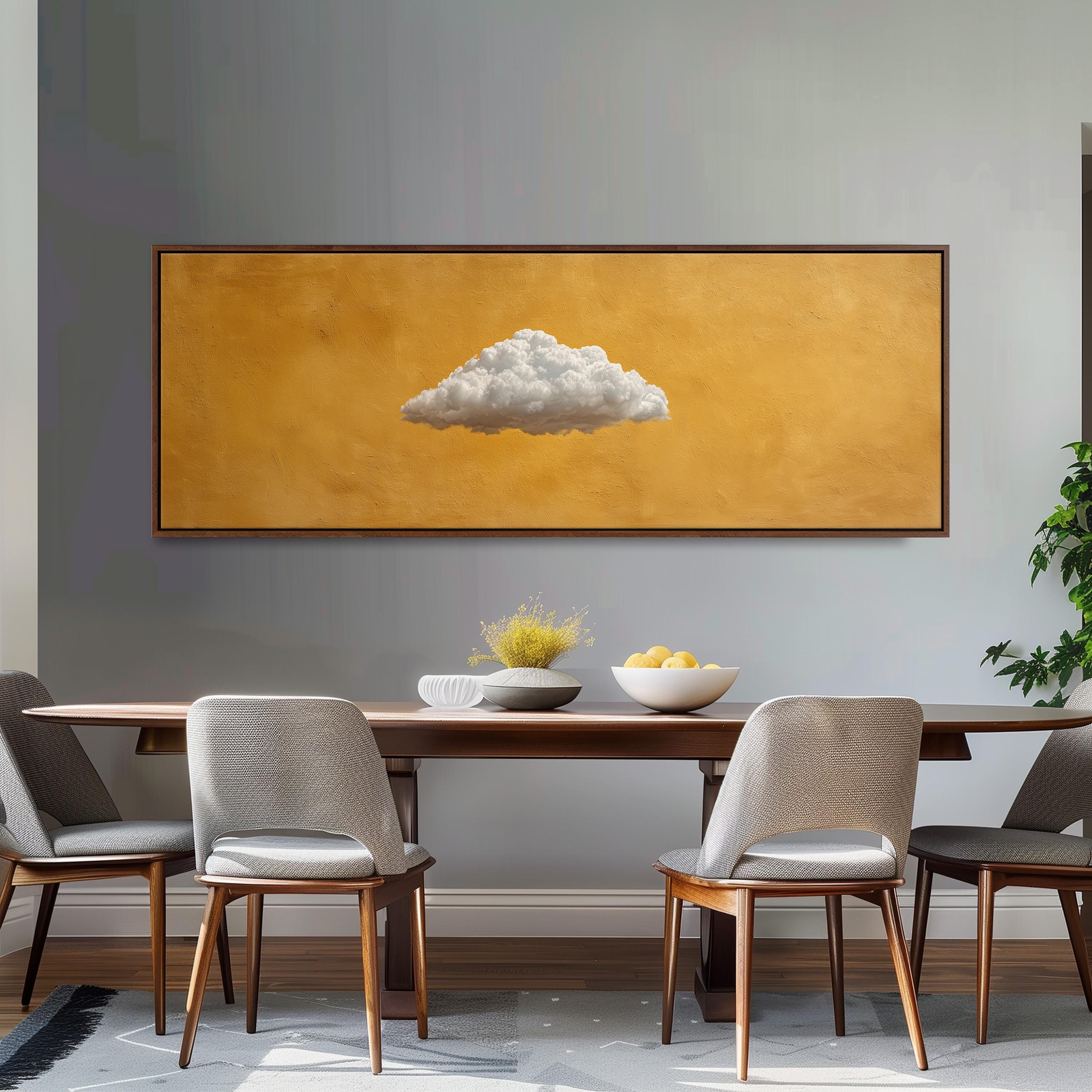 a dining room with a wooden table and four chairs. Above the table, there is a large painting of a cloud on an orange background. The table is set with a bowl of fruit and a vase of flowers.