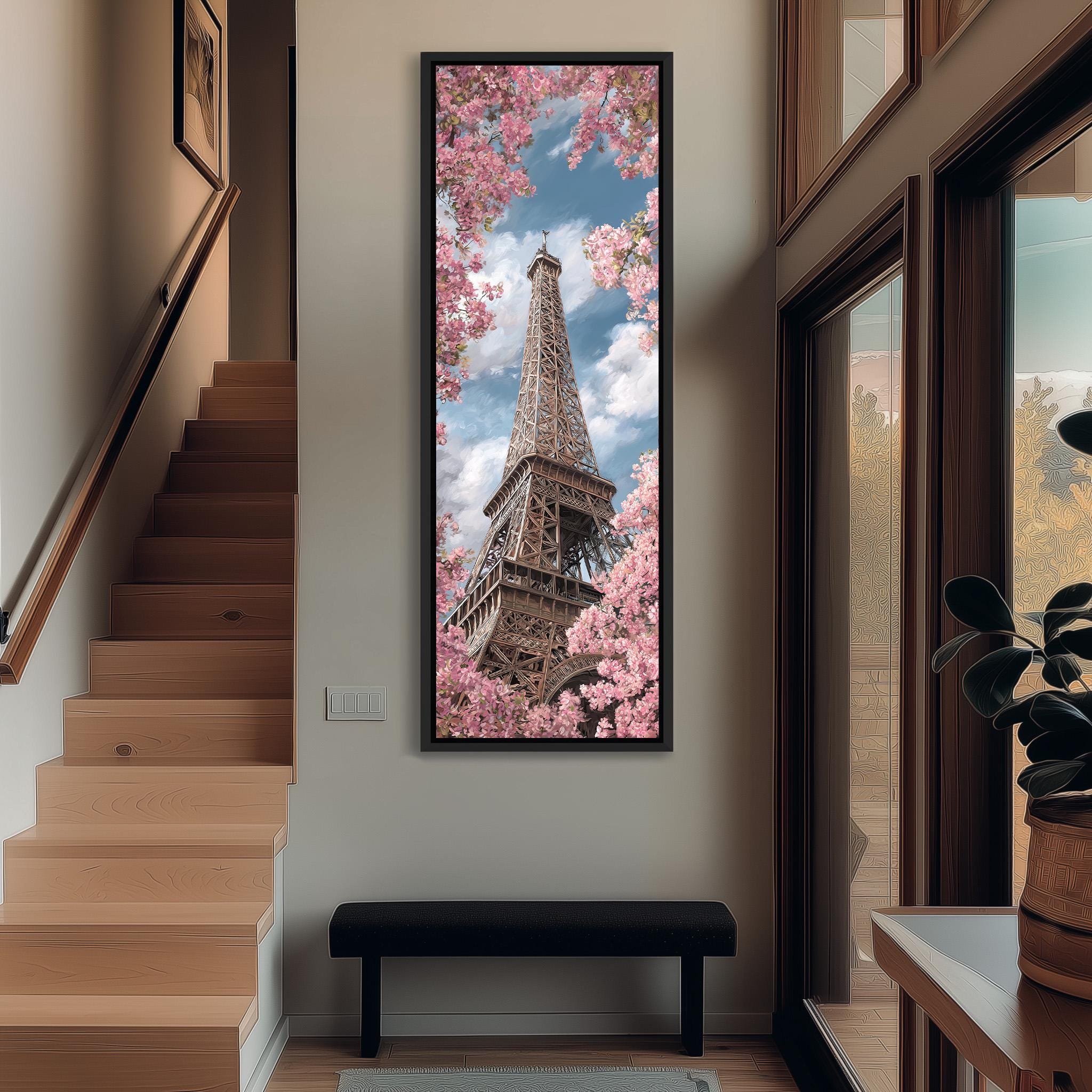 a large framed picture of the Eiffel Tower with pink flowers in the background, hanging on a wall in a hallway.