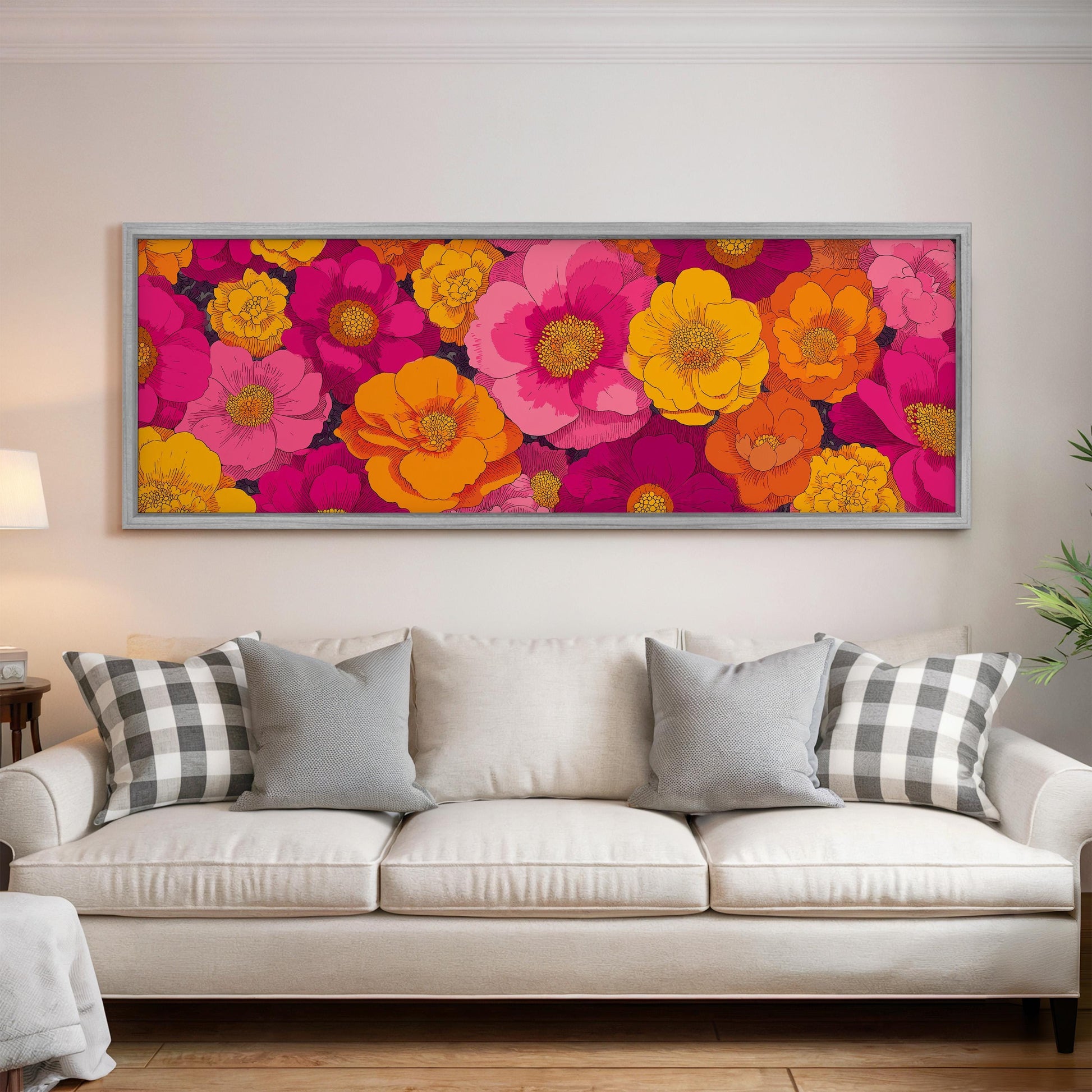 a large, colorful floral print hanging on a wall above a white couch with gray and white plaid throw pillows.