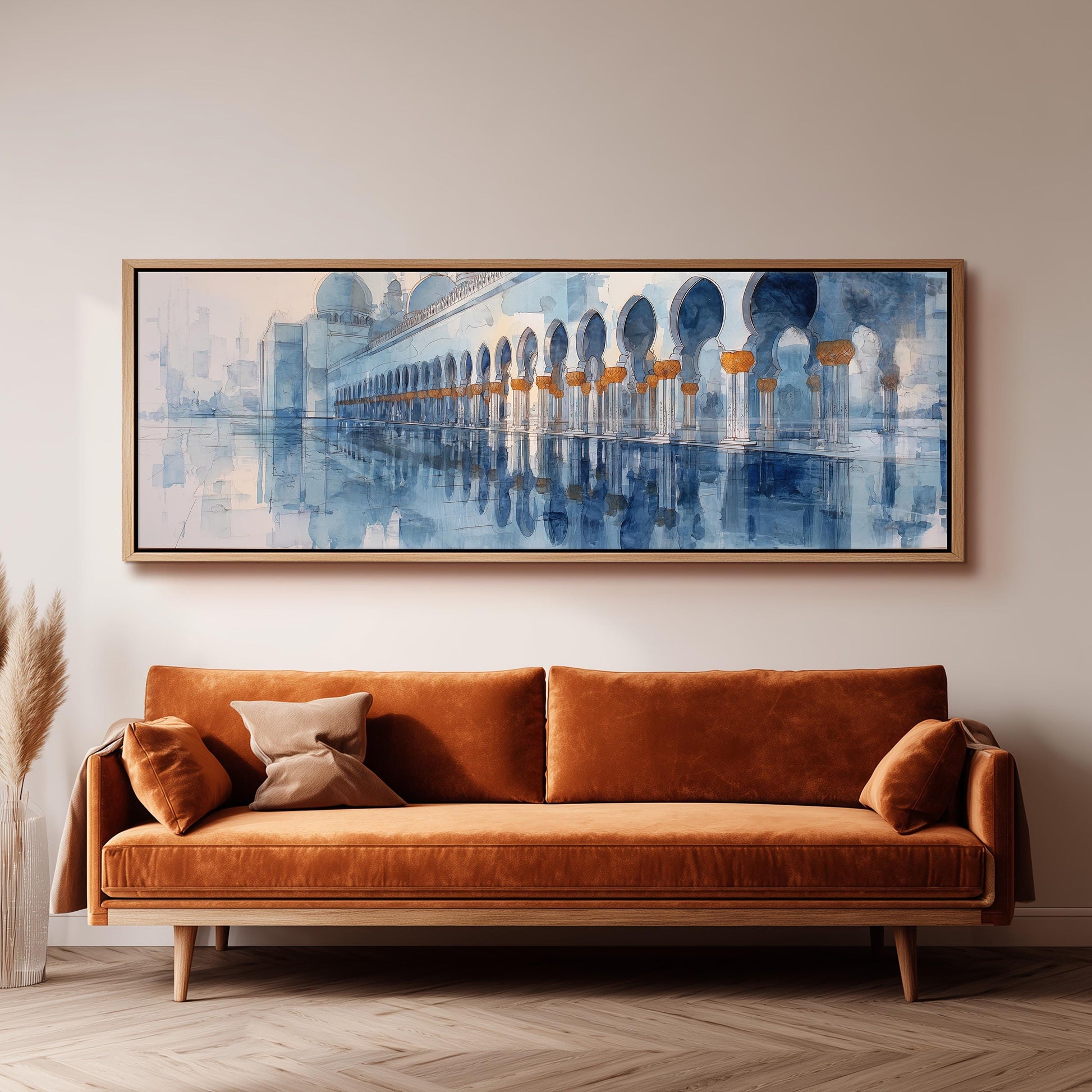 a large, framed painting of a building with arches hanging on a wall above a brown sofa.