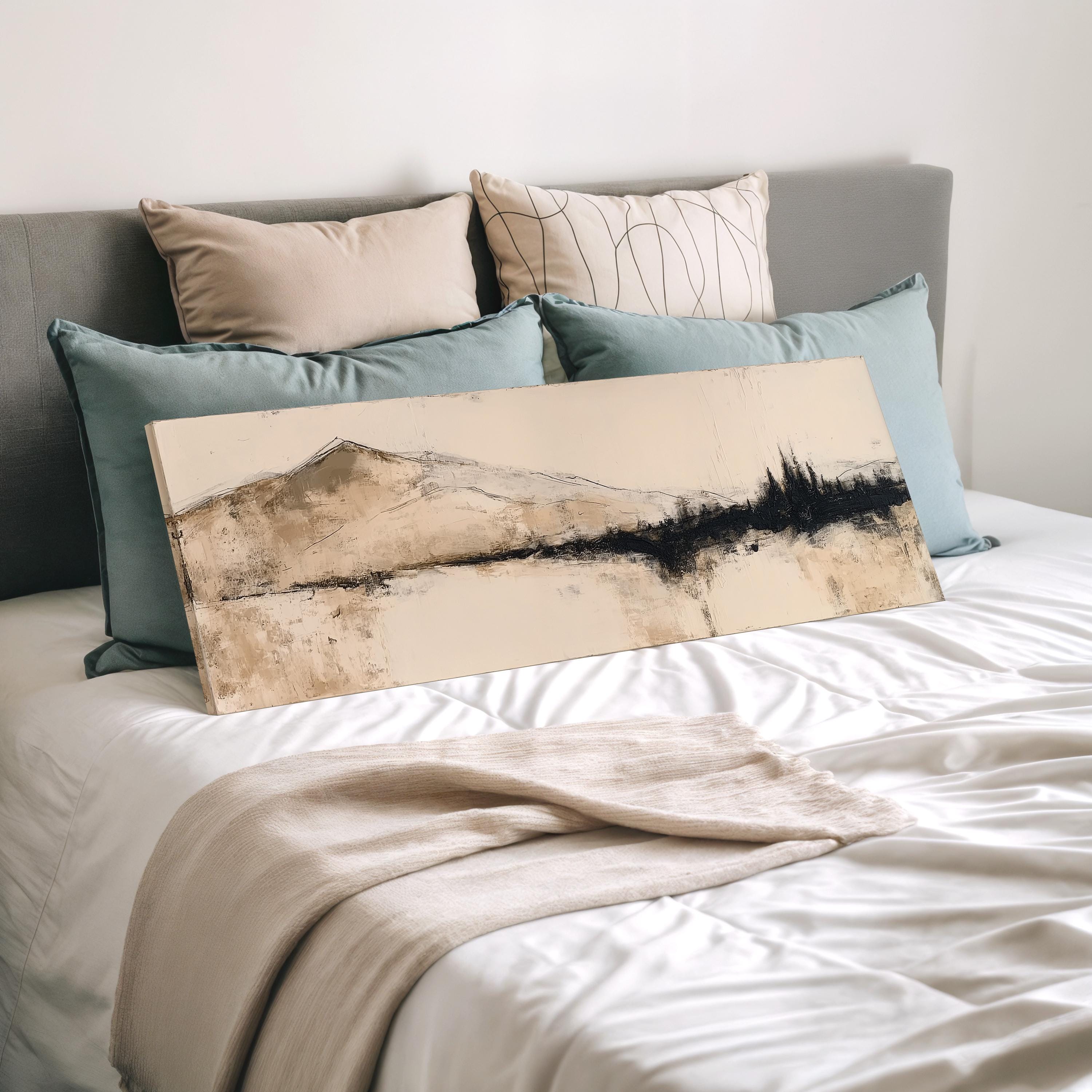 a bedroom with a bed and a large painting or artwork displayed on it. The bed is covered with white sheets and has several pillows arranged on it. The artwork is a landscape painting depicting a mountain scene.