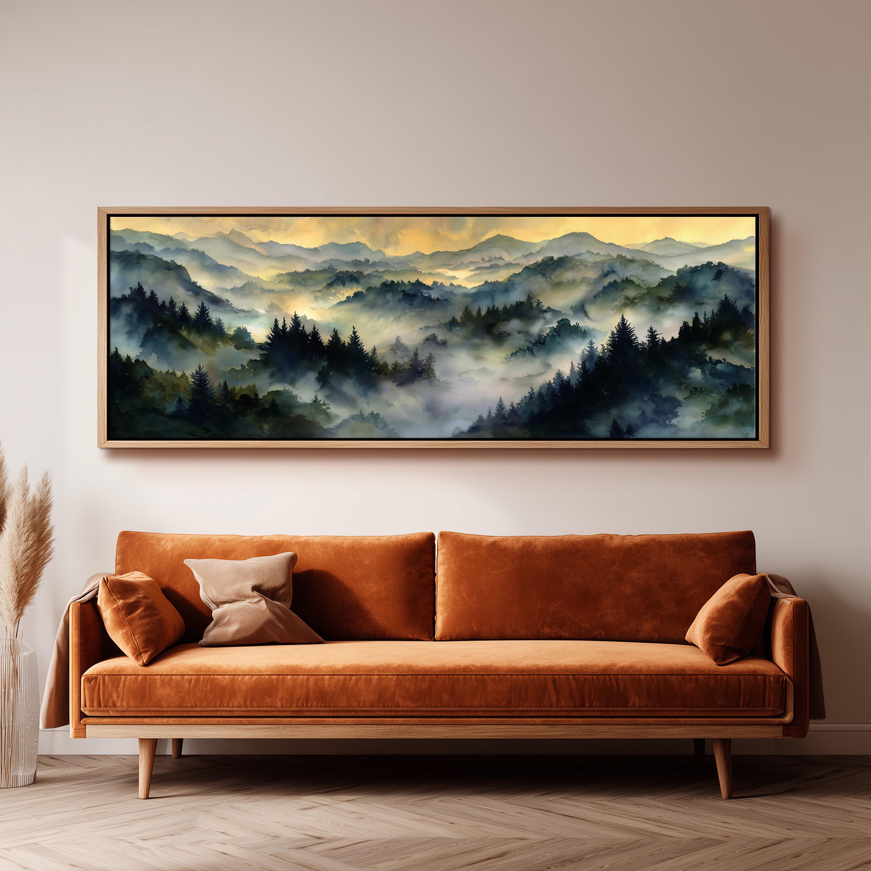 a large, framed painting of a mountainous landscape with a hazy, misty atmosphere. The painting is hanging on a wall above a brown sofa, creating a cozy and inviting atmosphere in the room.